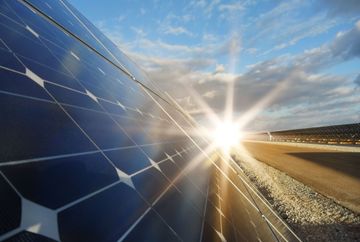 A close up of a solar panel with the sun shining through it