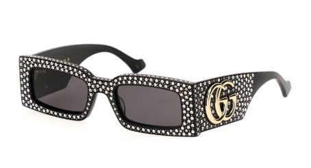 Black studded sunglasses with dark lenses and a gold logo on the side