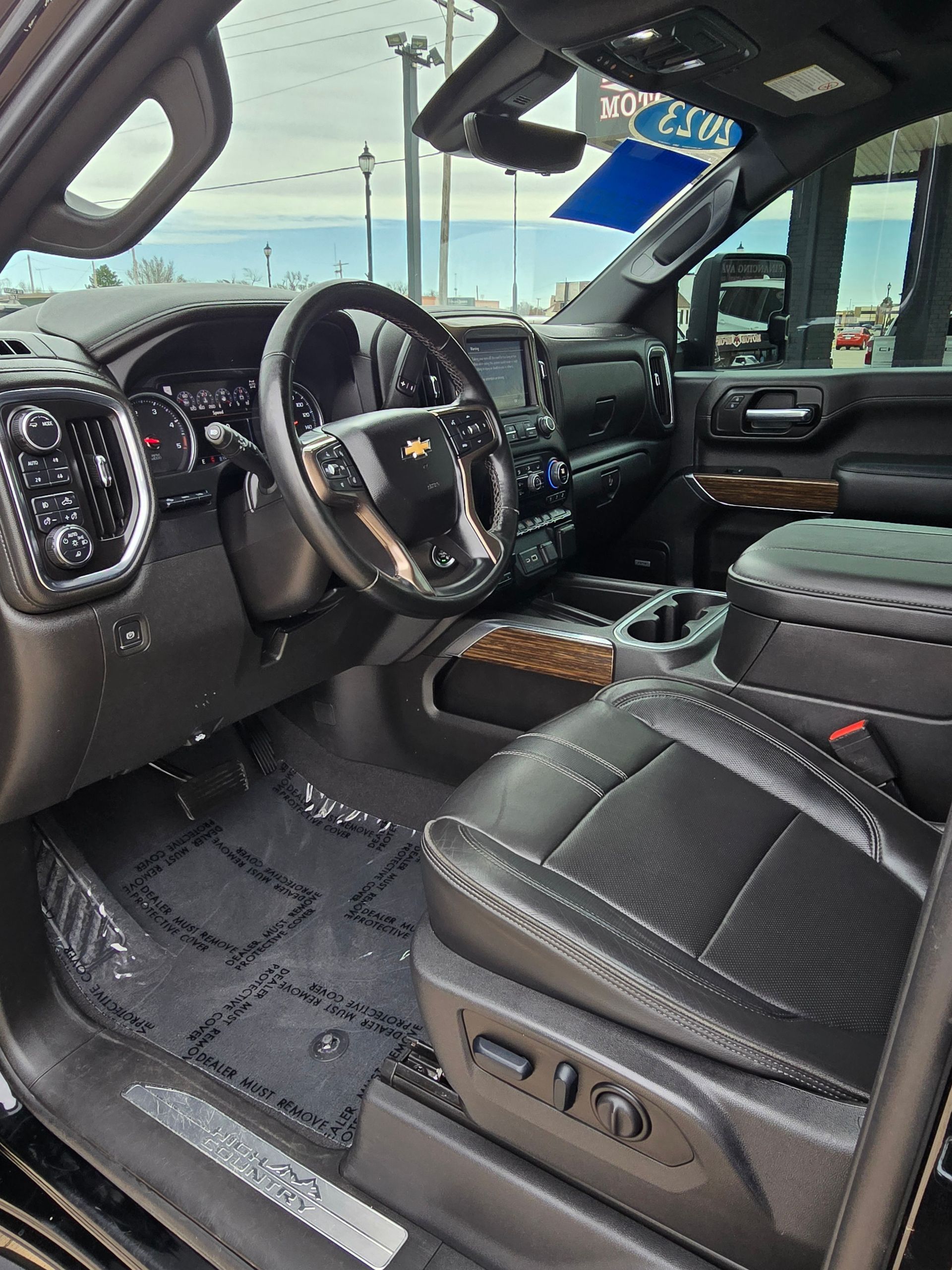 Black interior of a Chevrolet Silverado truck with leather seats, steering wheel, and dashboard.