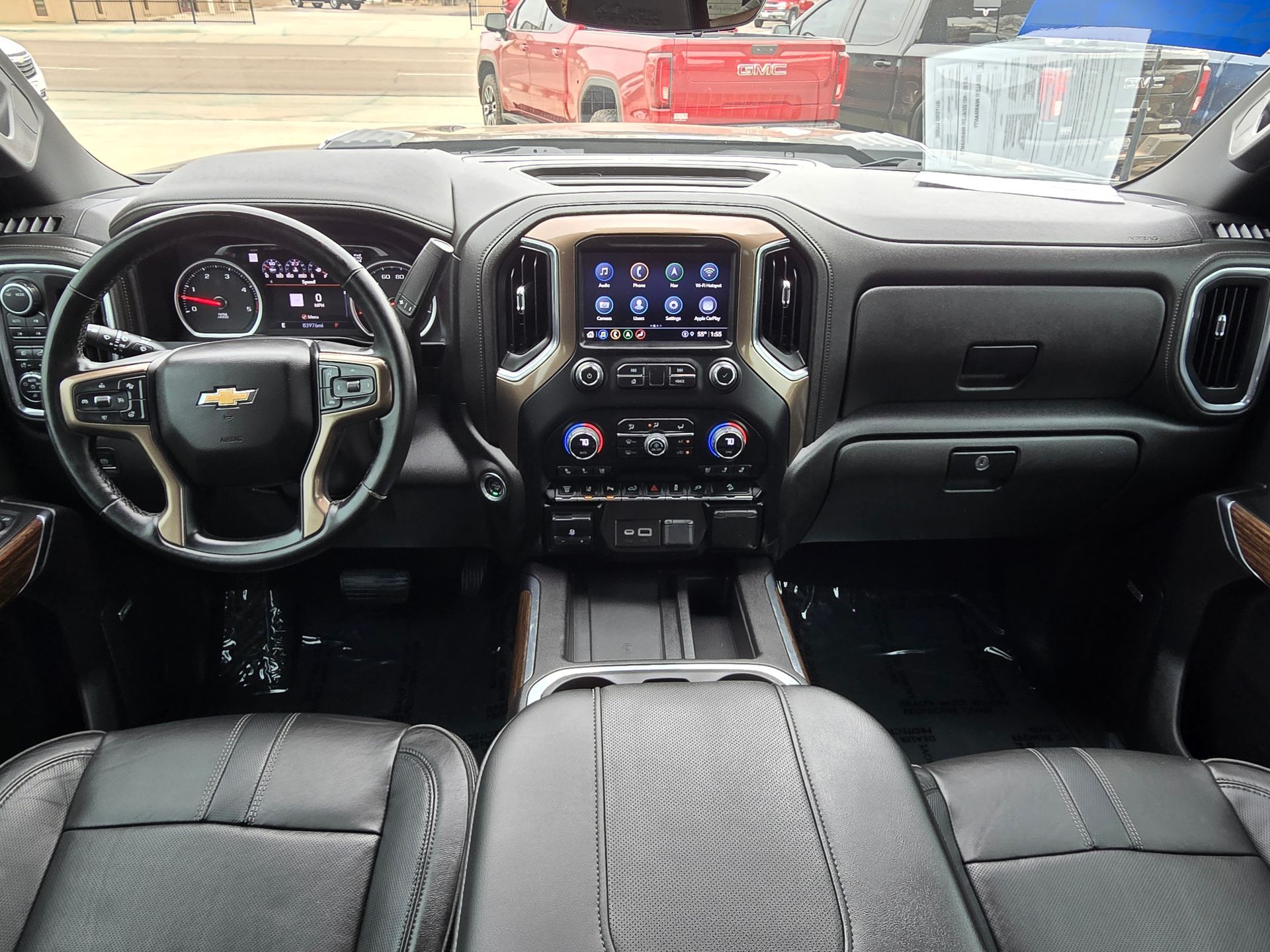 Interior view of a black Chevrolet truck dashboard, steering wheel, and console.