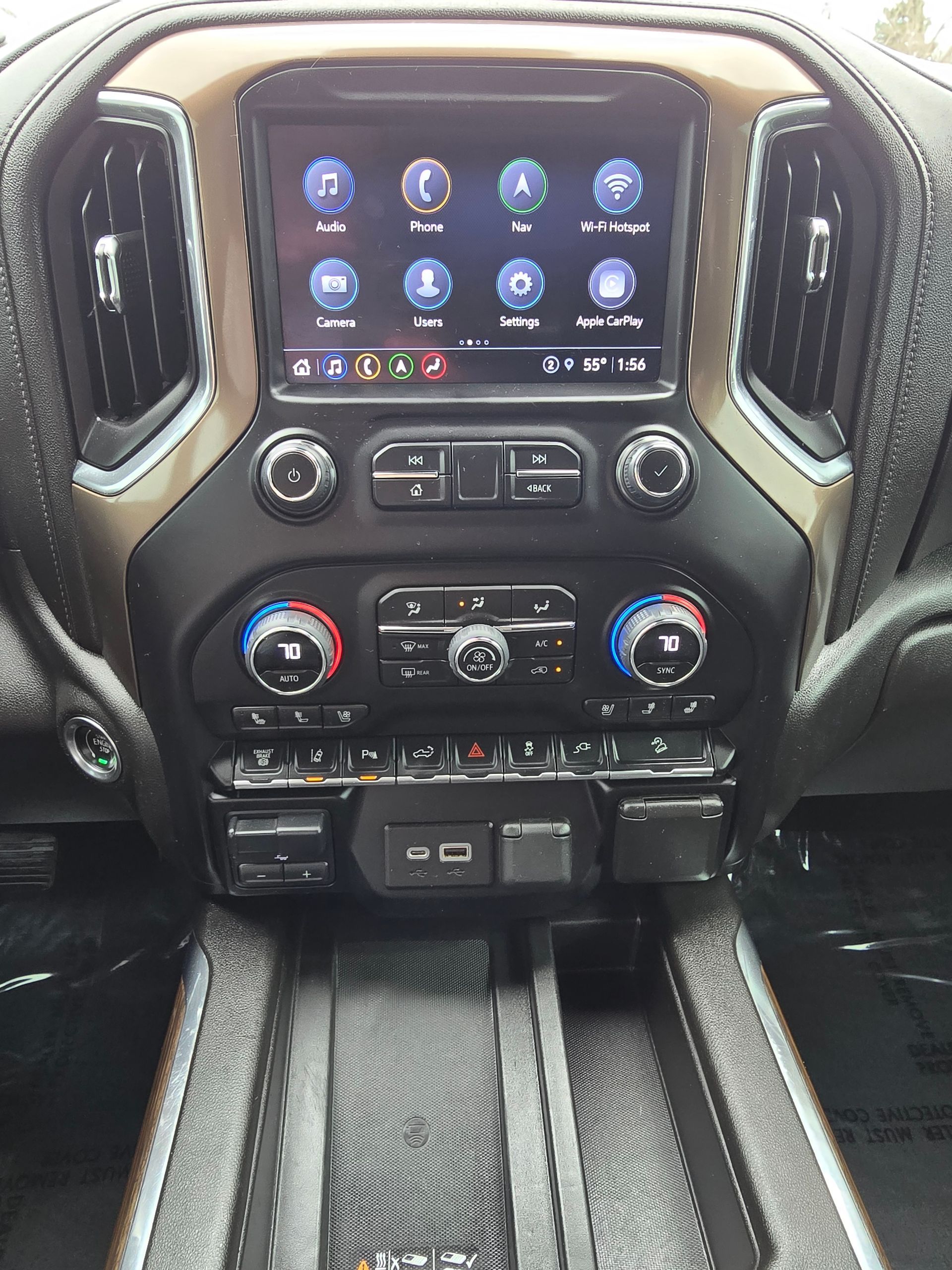 Dashboard of a vehicle featuring a touchscreen display, air vents, climate controls, and a console with USB ports.