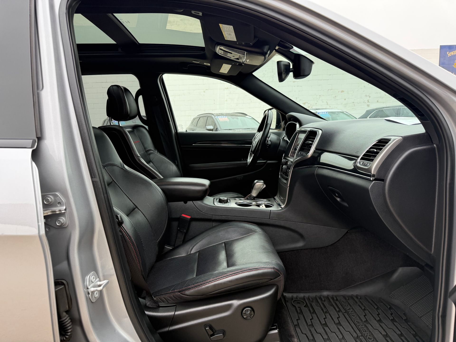 Gray SUV interior with black leather seats, sunroof, and dashboard.