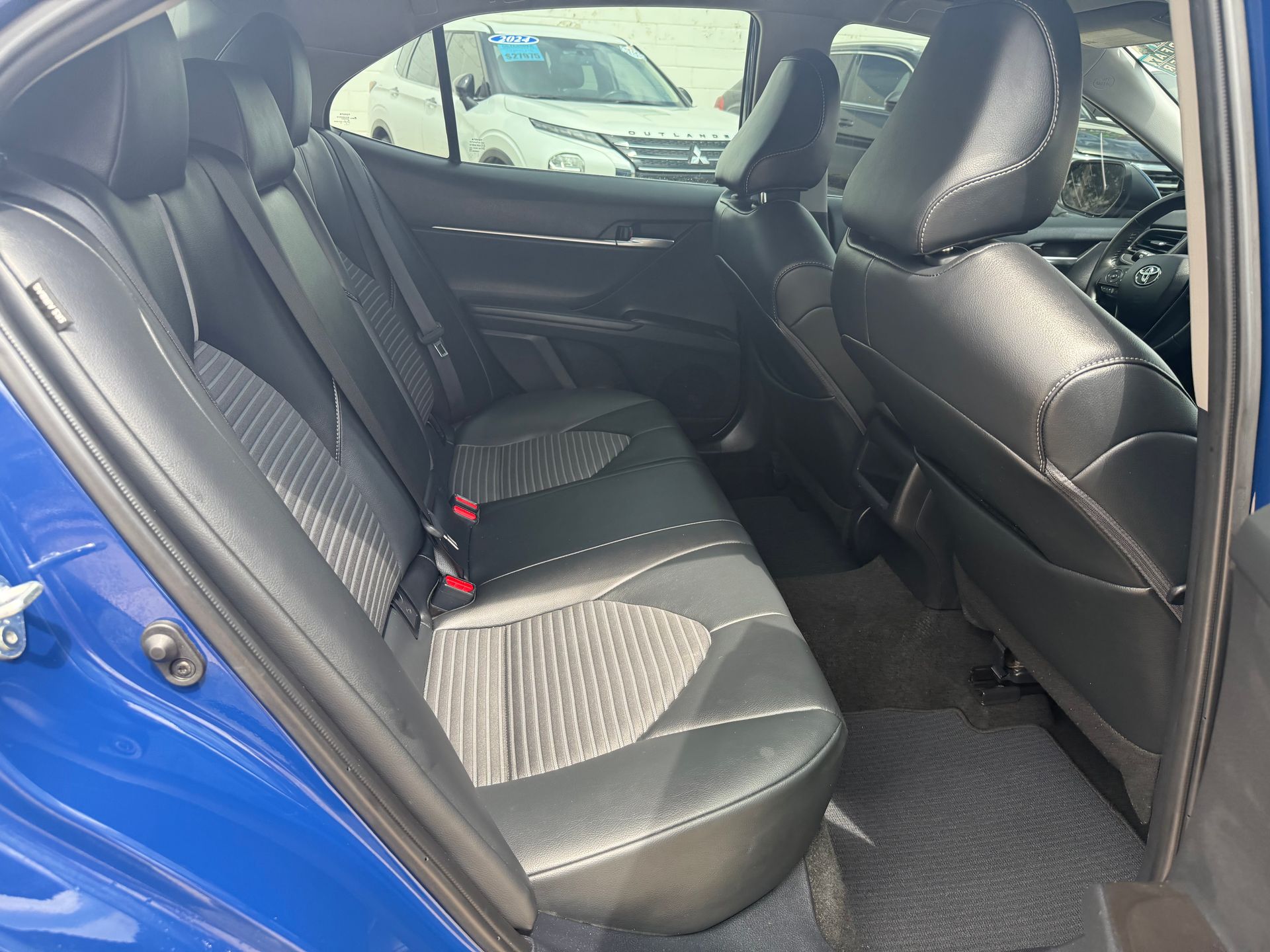Blue car interior with black leather seats and headrests.