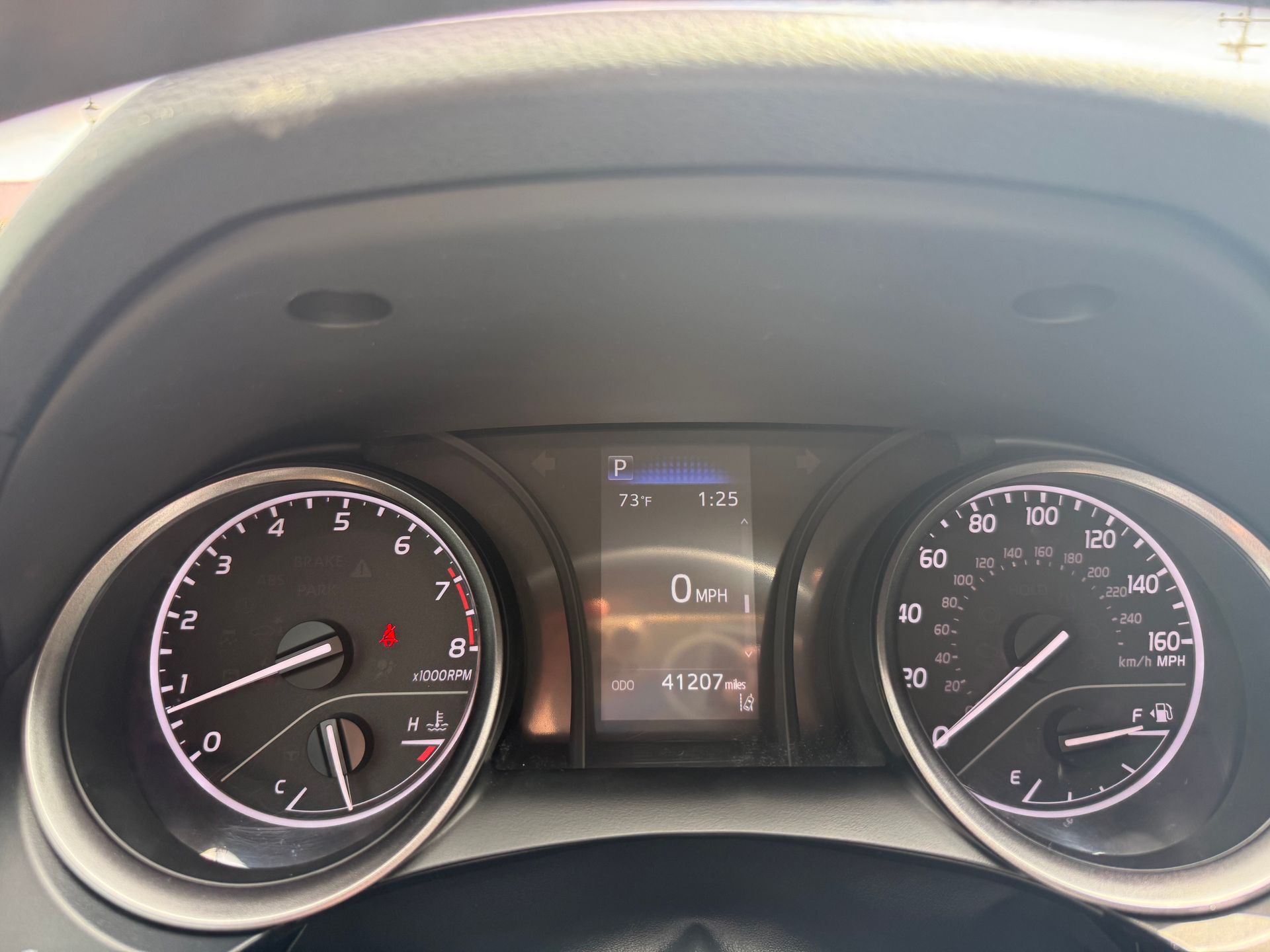 Dashboard of a car showing speedometer, tachometer, and digital display with information.