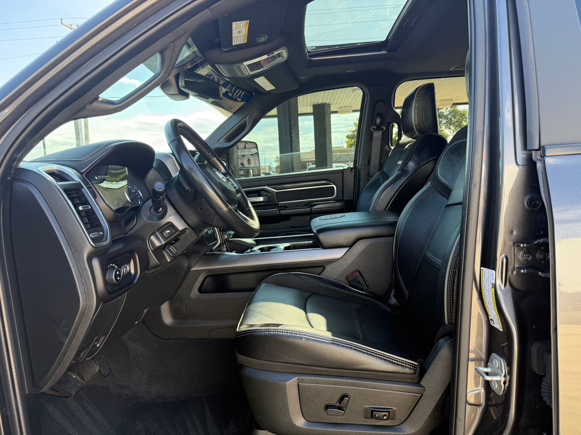 Black truck interior, driver's side view. Leather seats, sunroof, steering wheel visible.