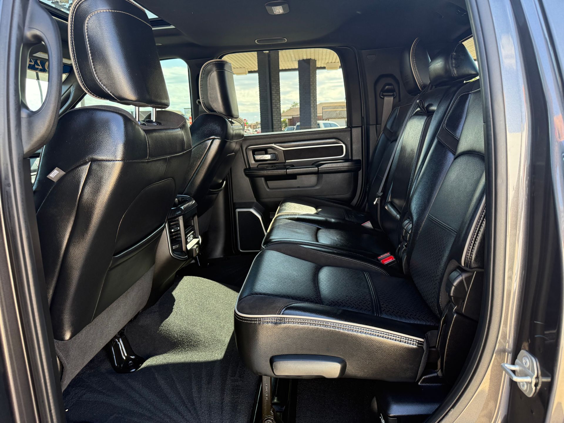 Black leather truck interior with seats, windows, and black carpeting.