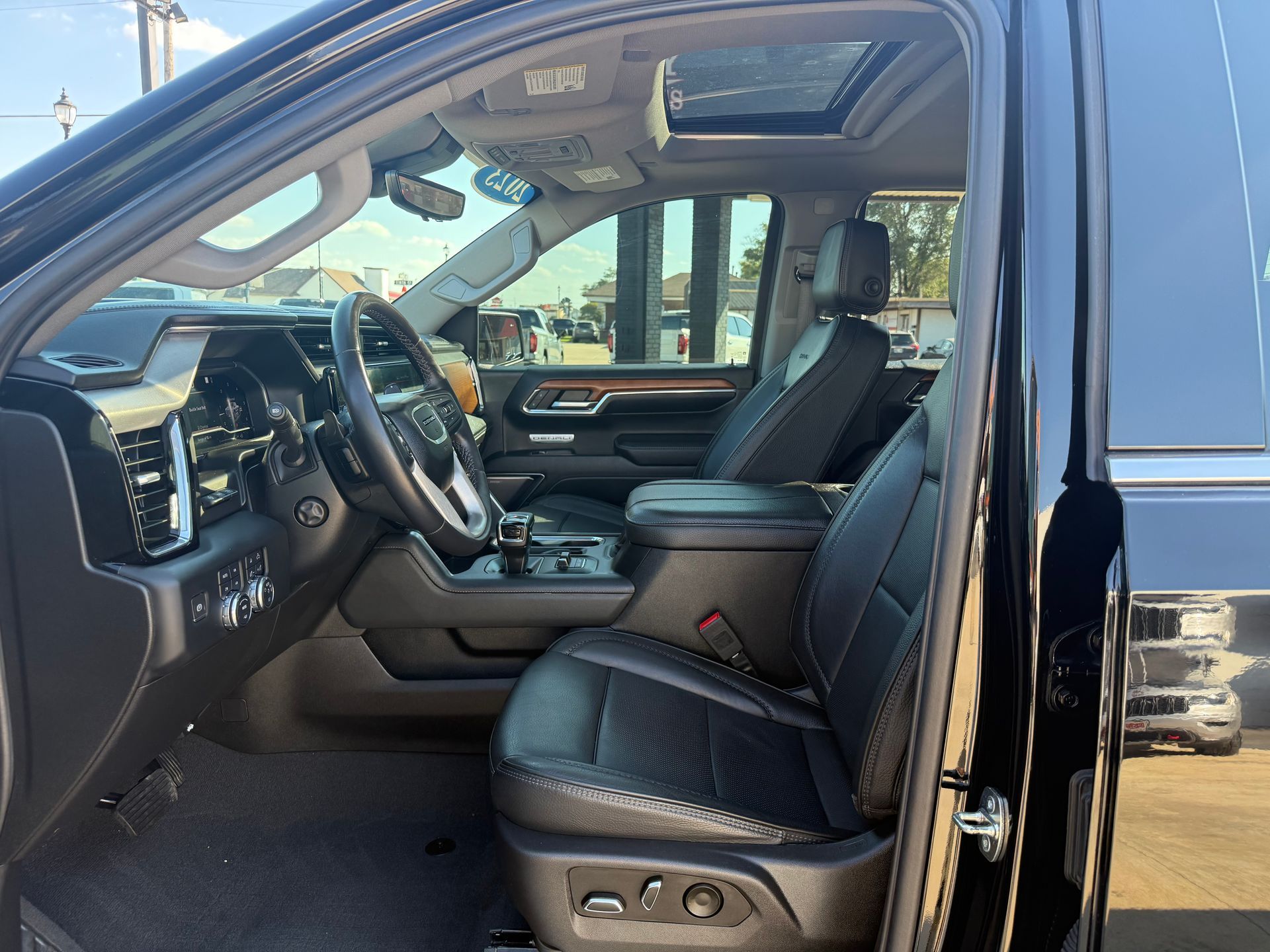 Black truck interior with leather seats, steering wheel, and sunroof.