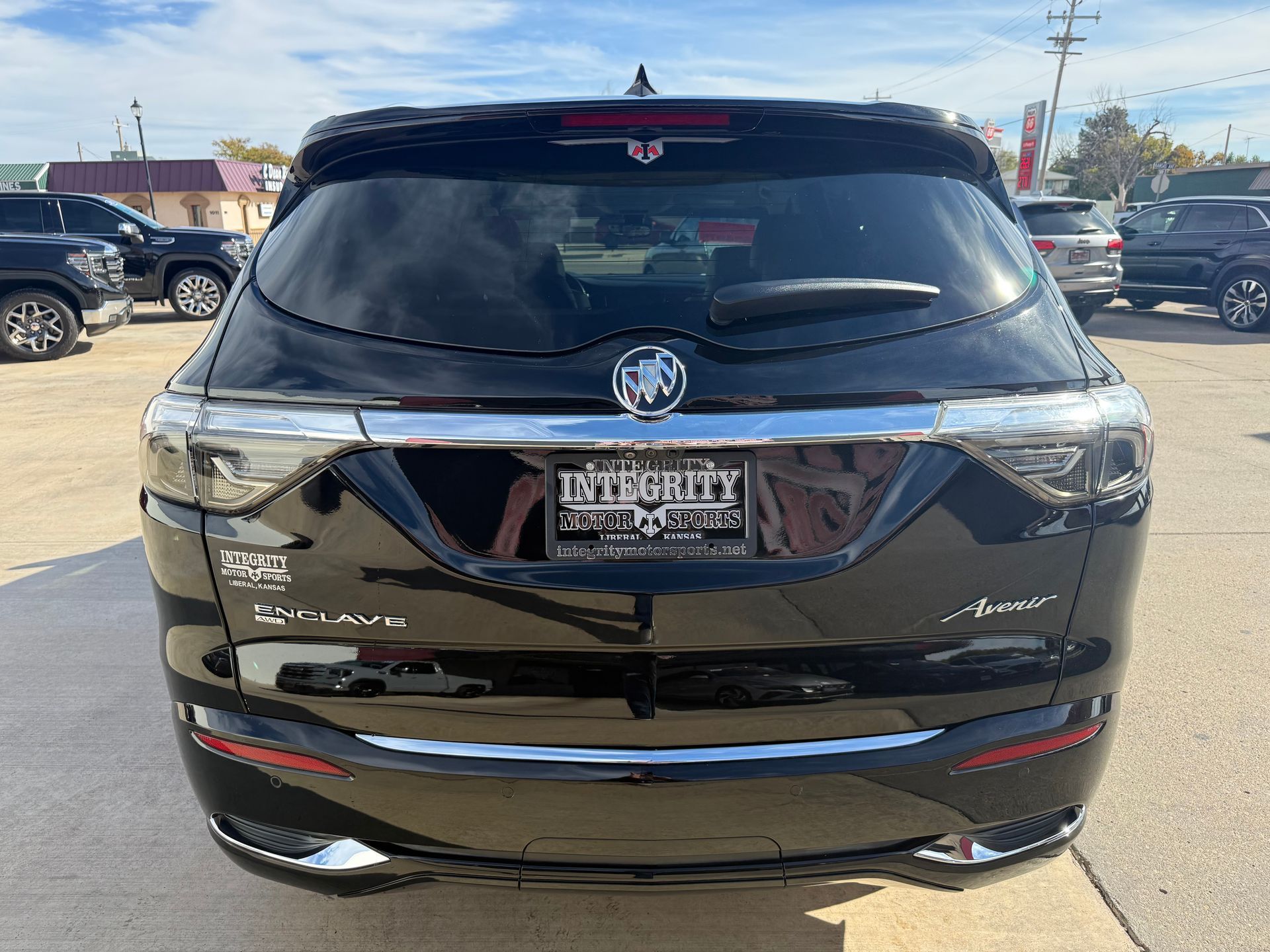 Black Buick SUV, rear view, parked outdoors in a dealership.