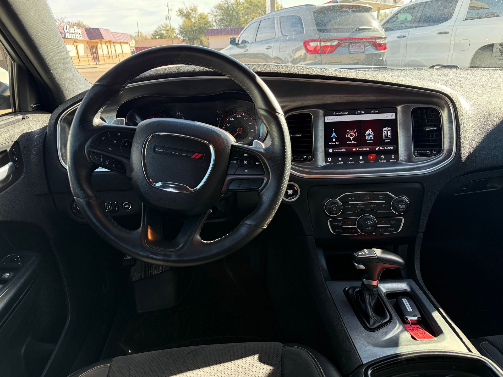 Dashboard of a Dodge Charger. Black interior with steering wheel, touchscreen, gear shift, and central console.