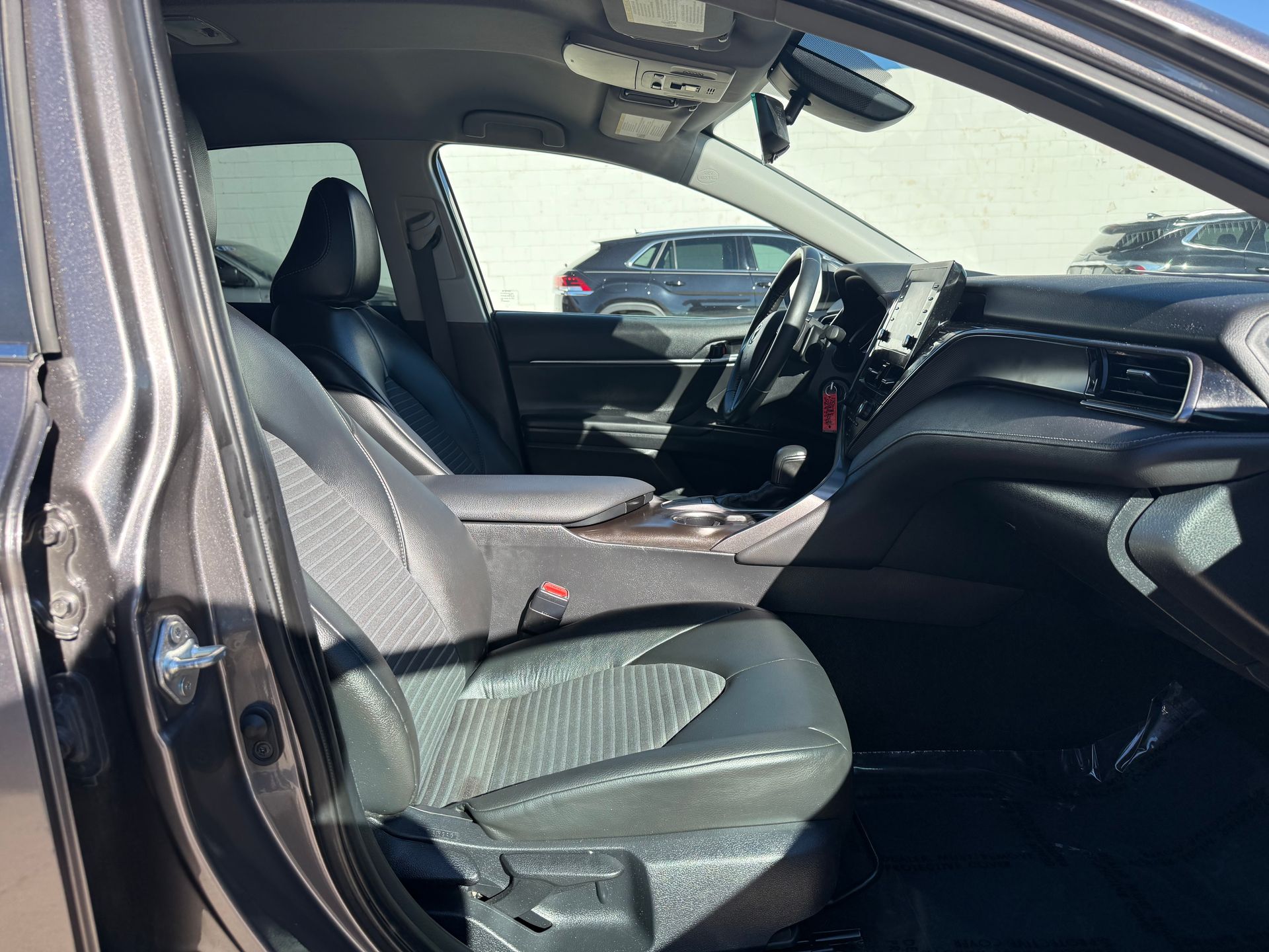 Interior view of a car with black leather seats, dashboard, and steering wheel.