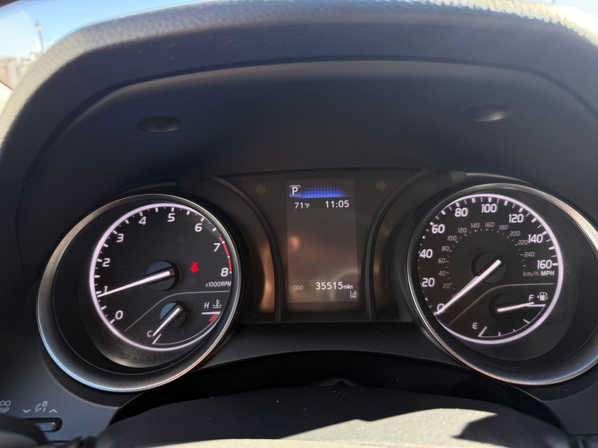 Dashboard of a car showing speedometer, tachometer, and display with mileage and fuel level.