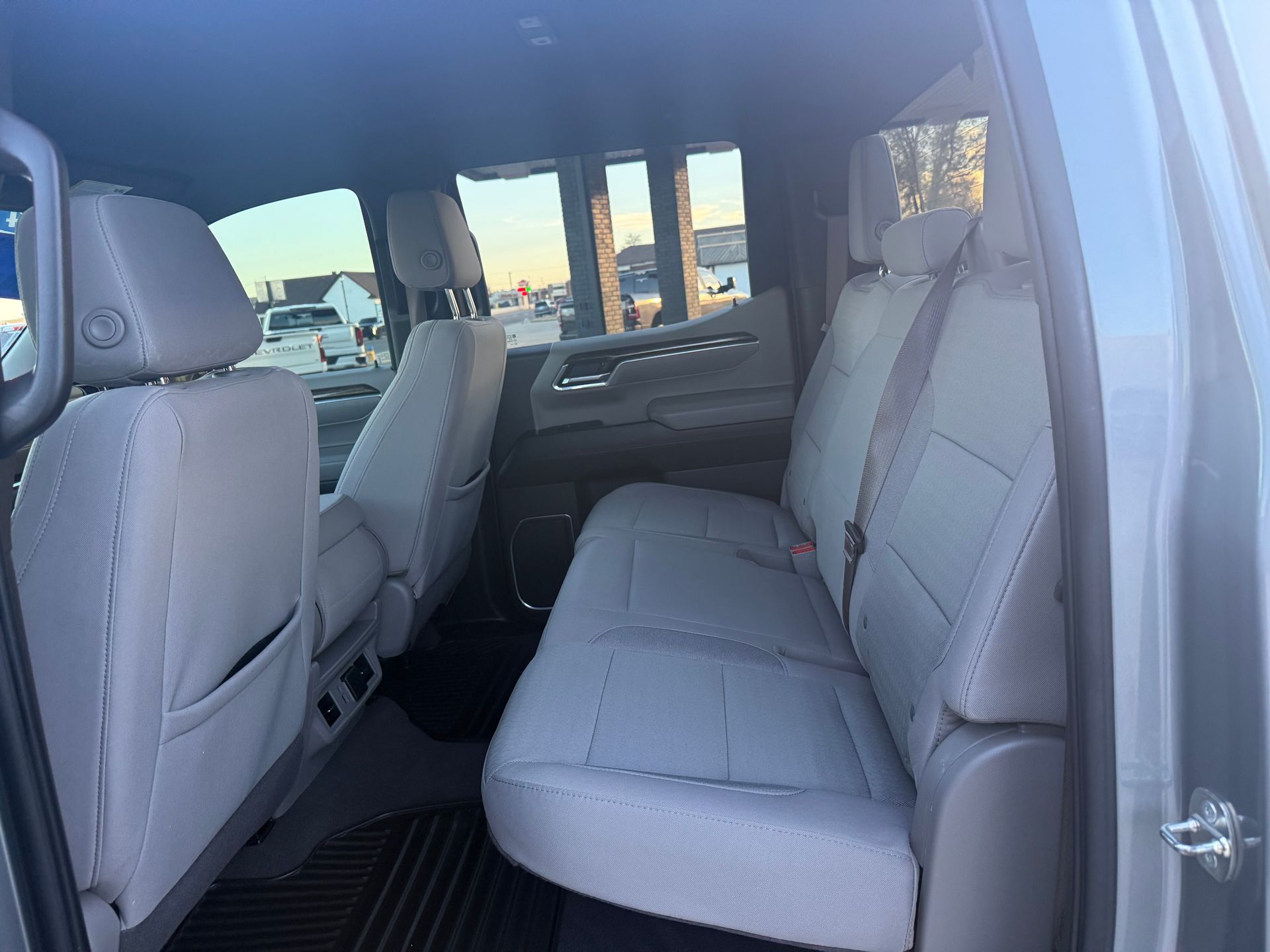 Gray truck interior with rear seats, and sunlight through the windows.