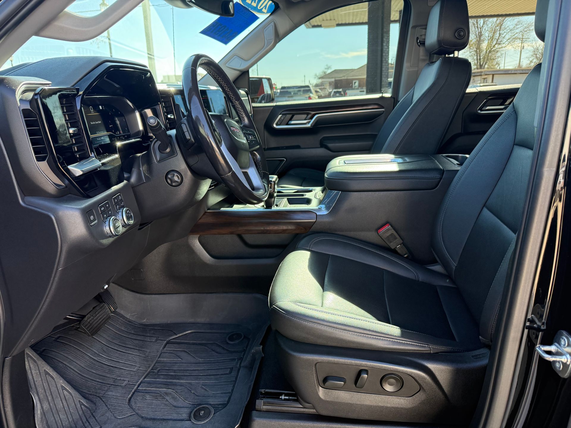 Black truck interior with leather seats, steering wheel, dashboard, and floor mats.