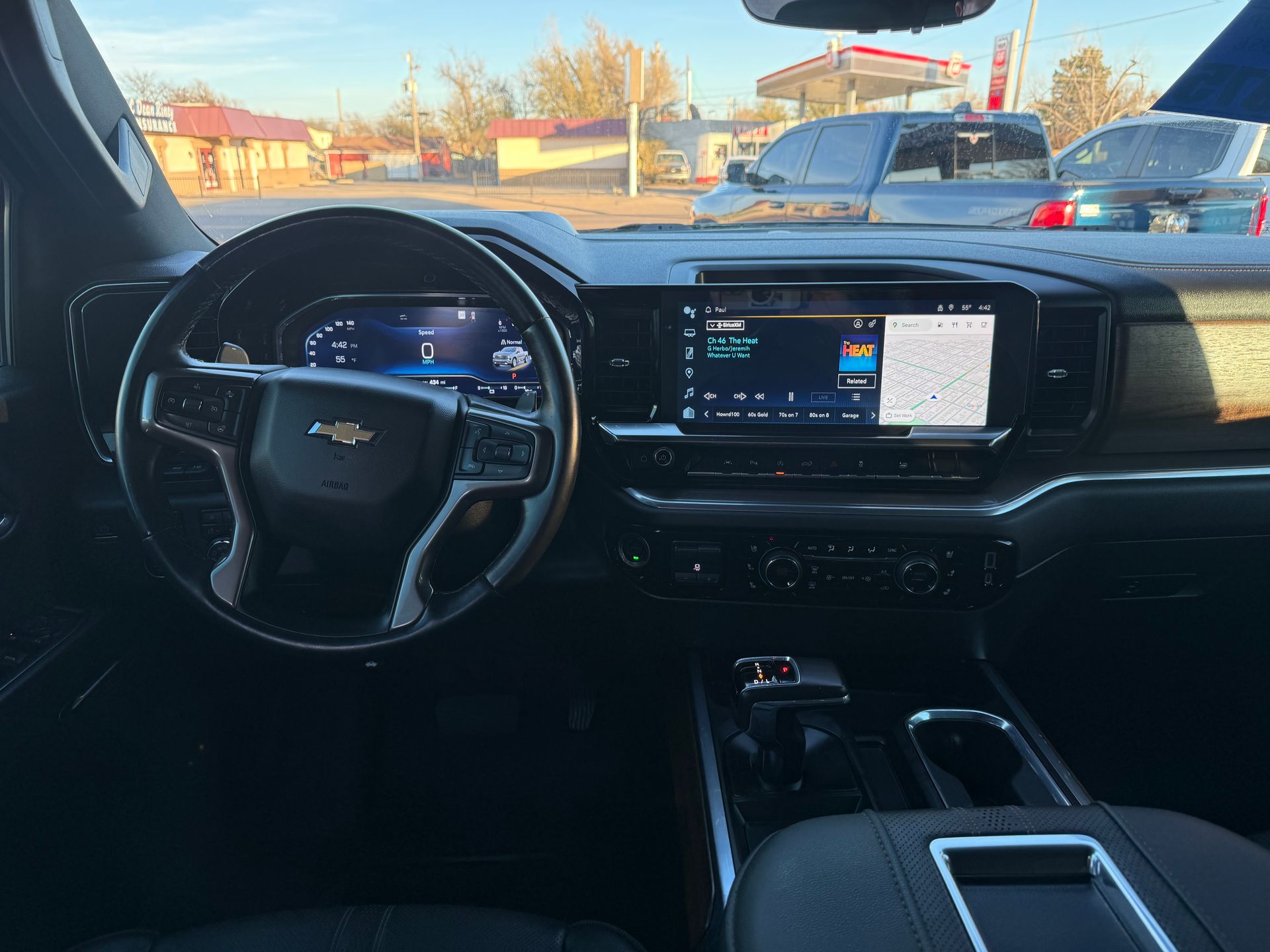 Interior view of a Chevrolet truck dashboard and steering wheel, with infotainment screen on.