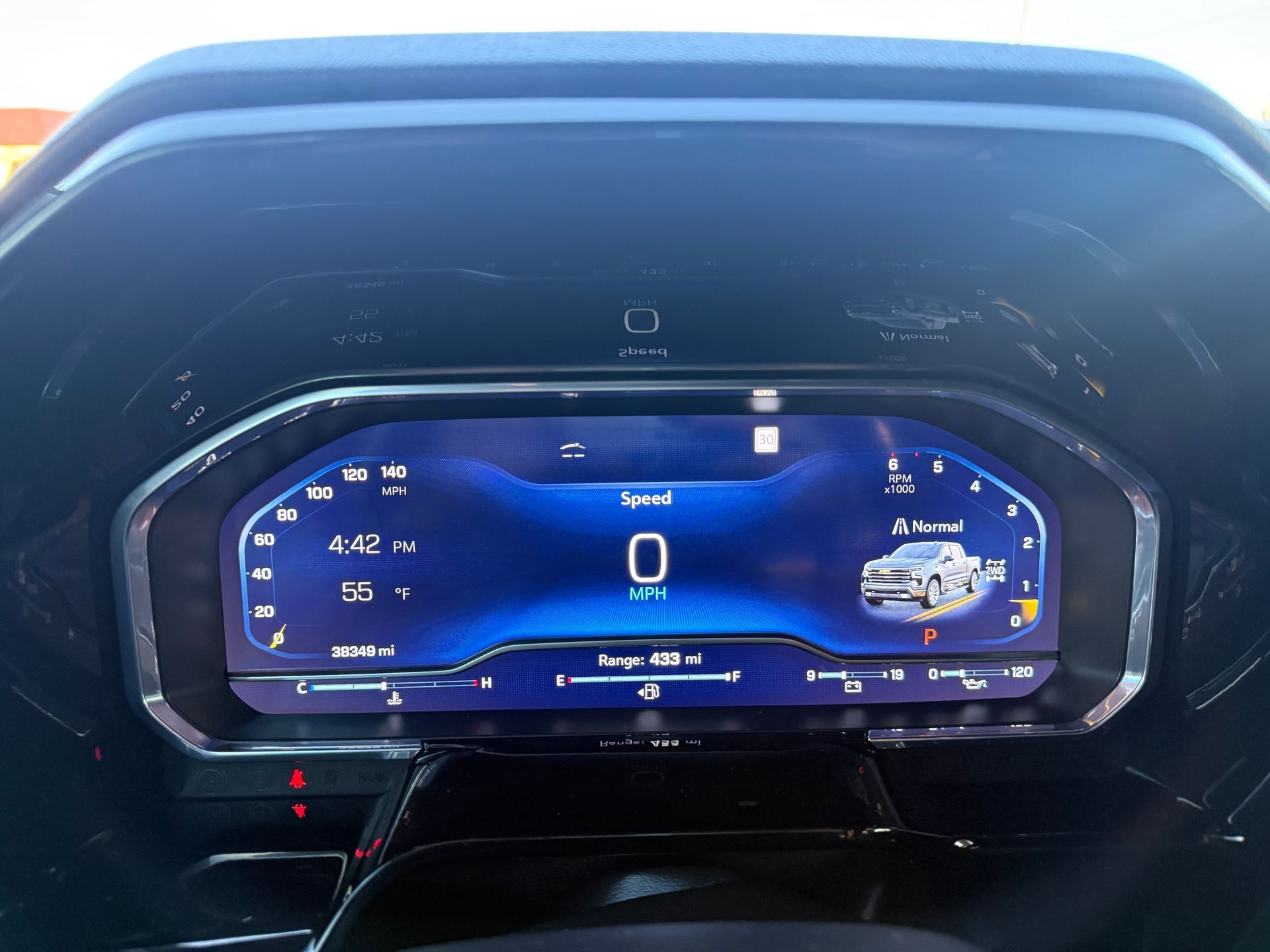 Car dashboard displaying speed at 0 mph. Features time, range, and vehicle graphics on a blue screen.