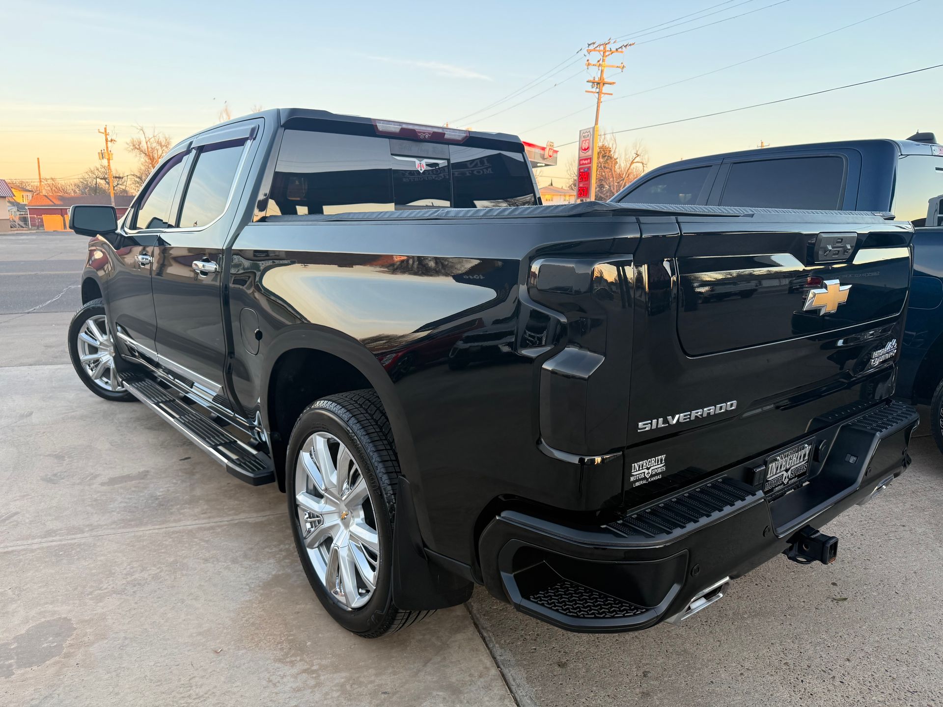 Black Chevrolet Silverado pickup truck with chrome wheels parked outdoors.