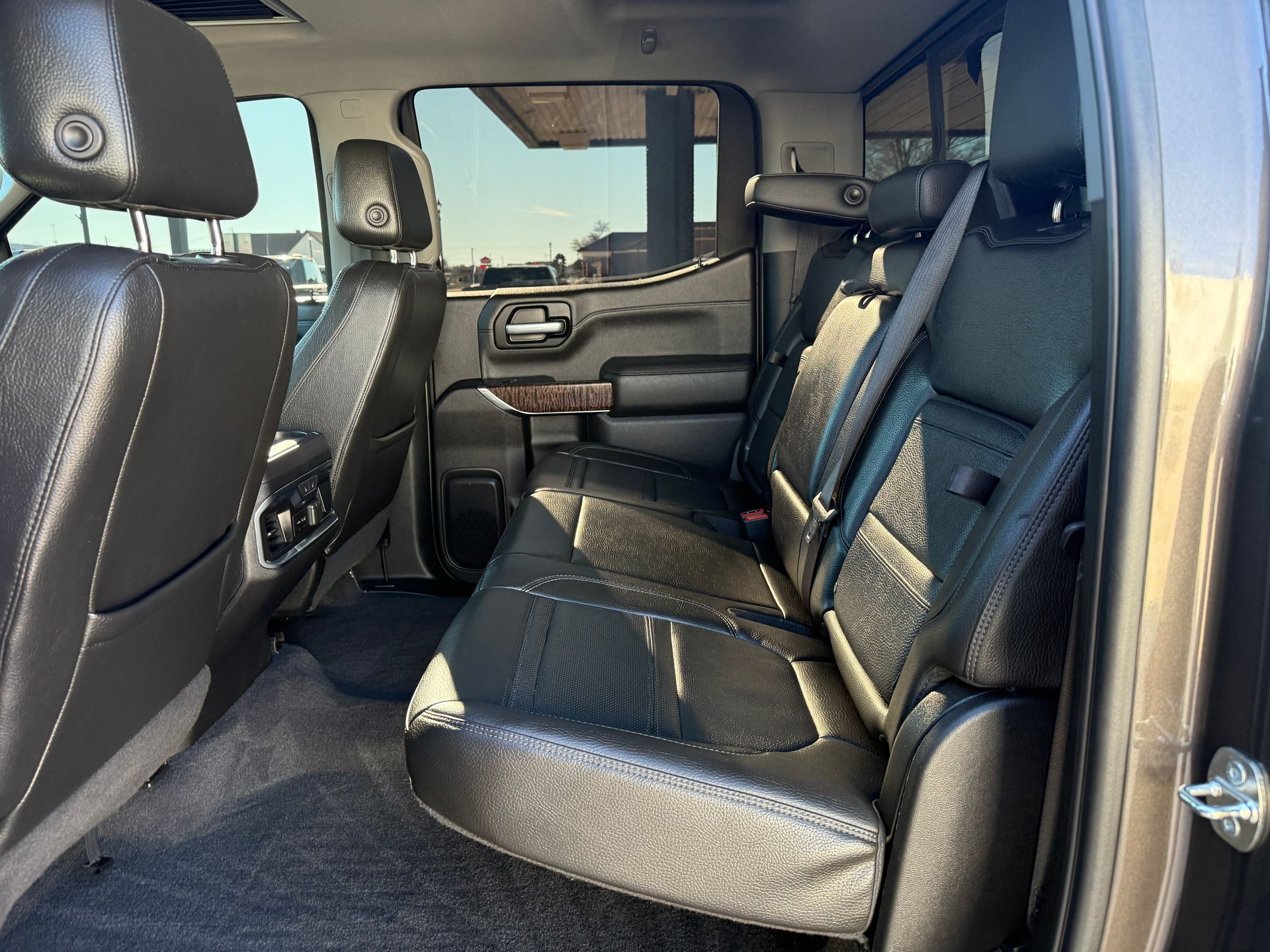 Black leather backseats of a pickup truck, with headrests.
