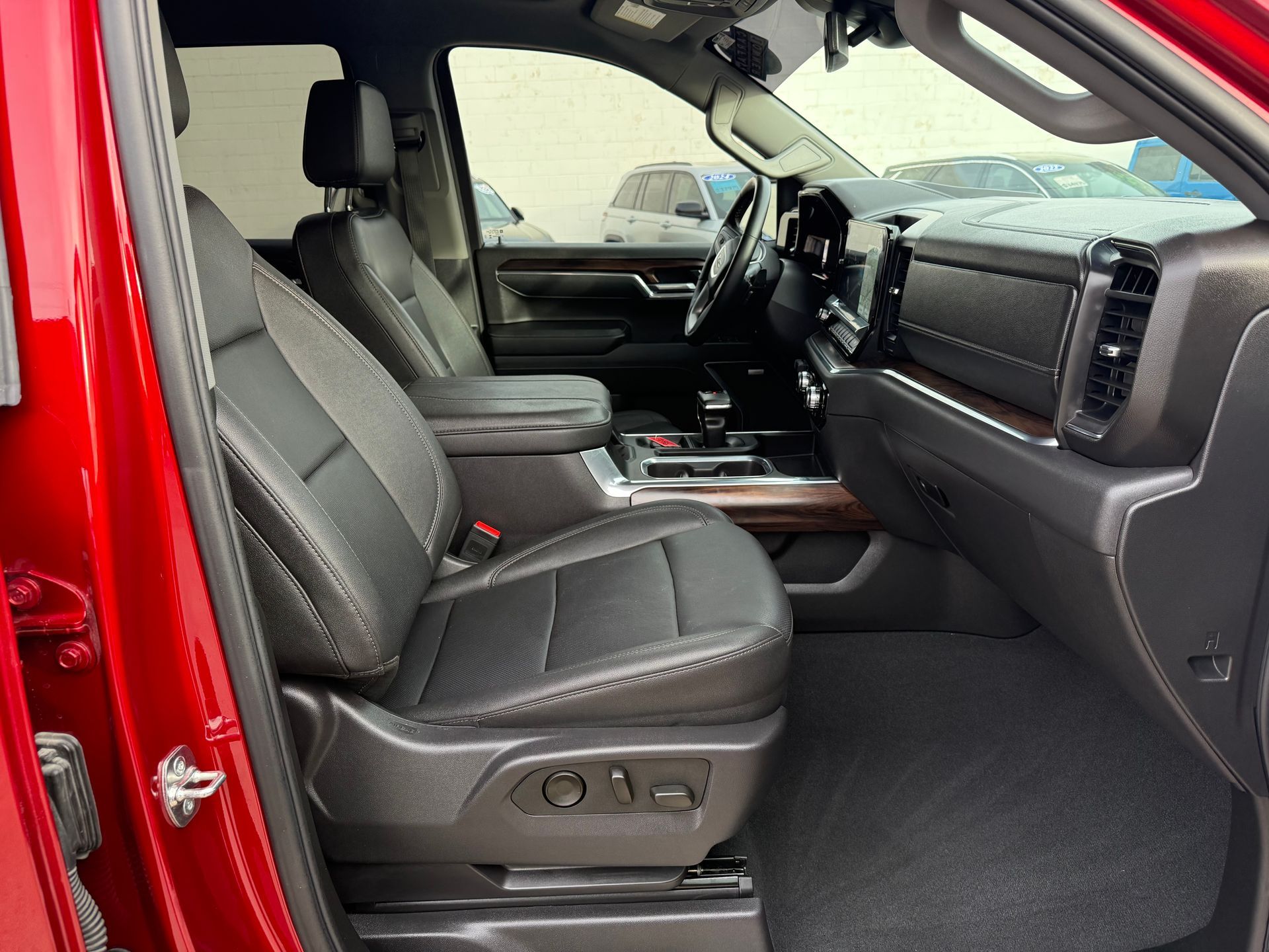 Red truck interior with black leather seats, dashboard, and floor mats.