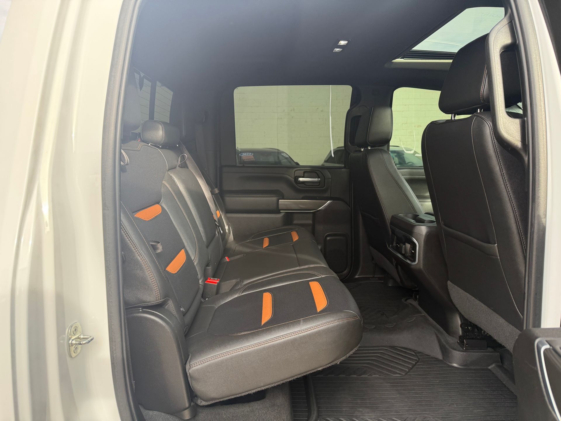 Truck's rear interior with black seats, orange accents, and a sunroof.