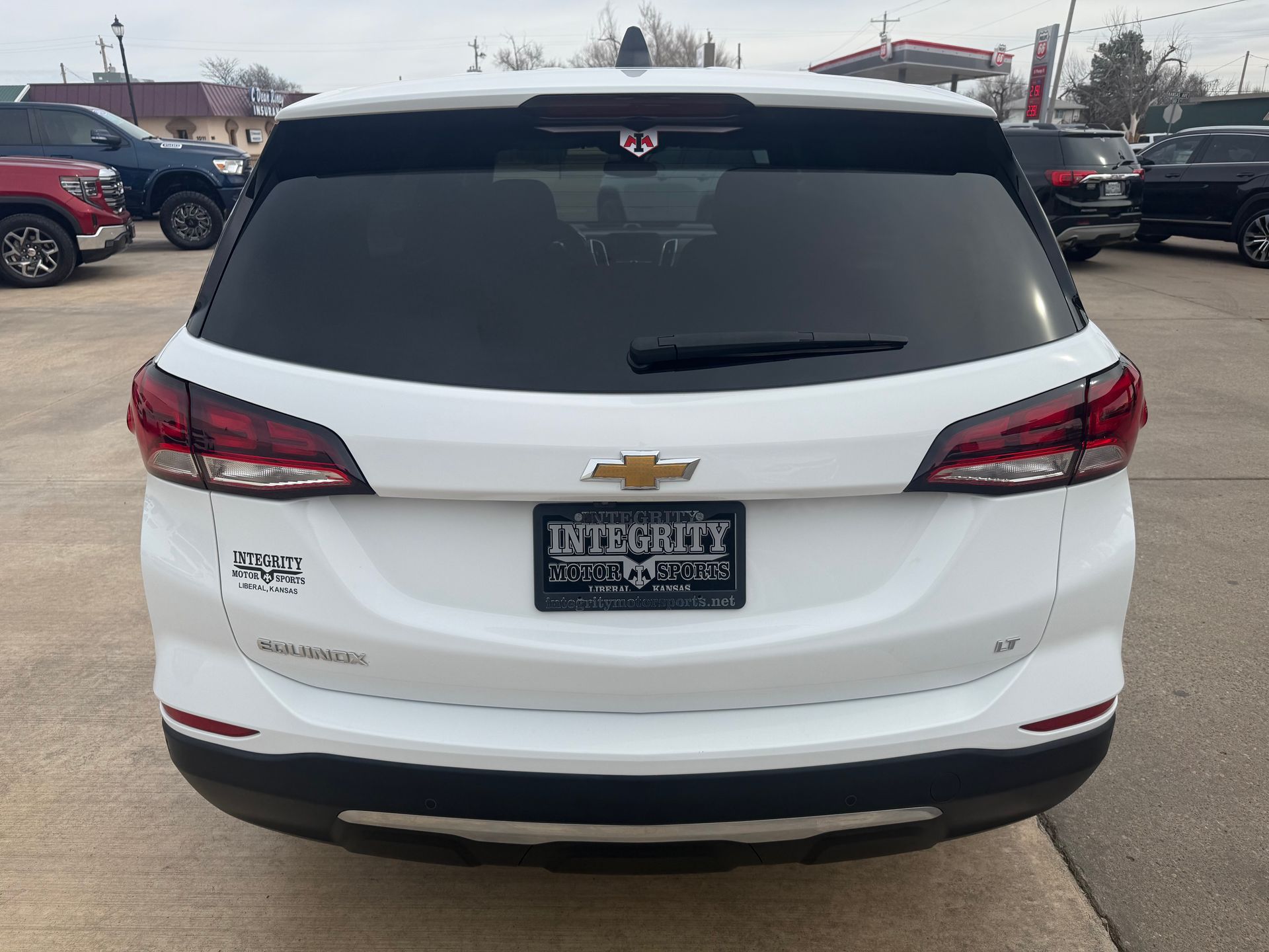 White Chevrolet Equinox SUV, rear view, in a car lot.