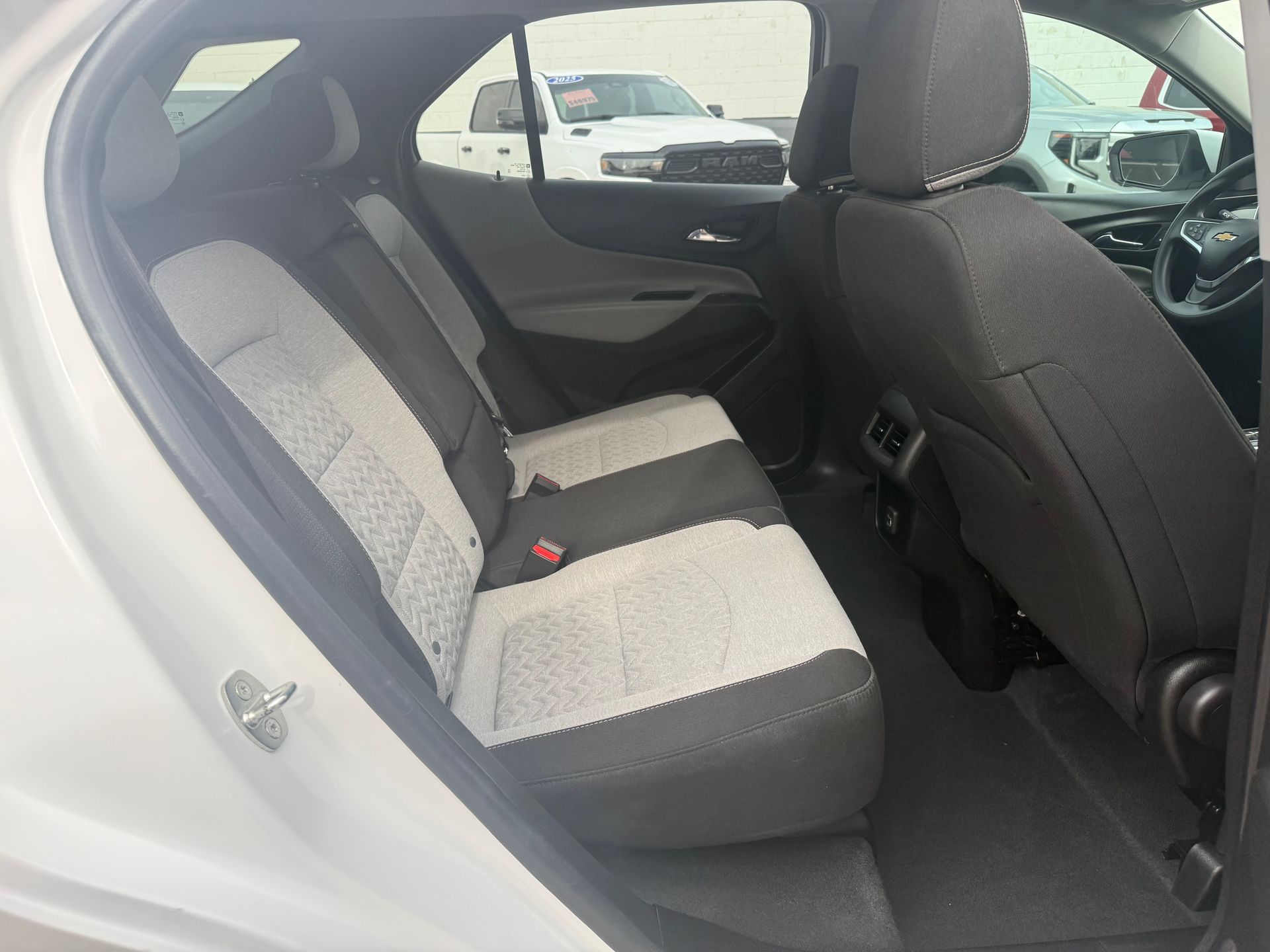 Rear interior view of a white SUV, showing gray and white seats.
