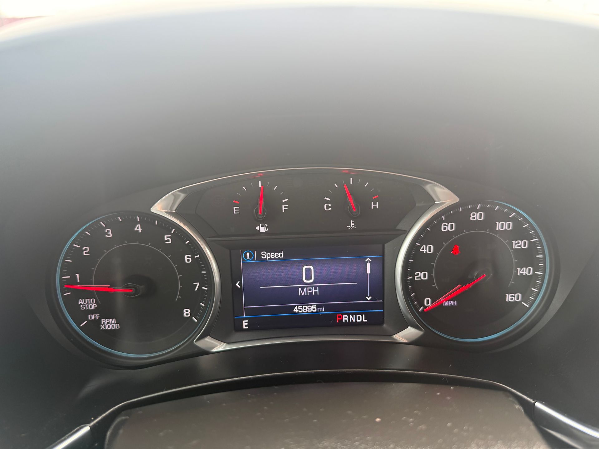 Car dashboard showing speedometer at 0 mph. Tachometer and fuel gauge visible. Digital display shows information.