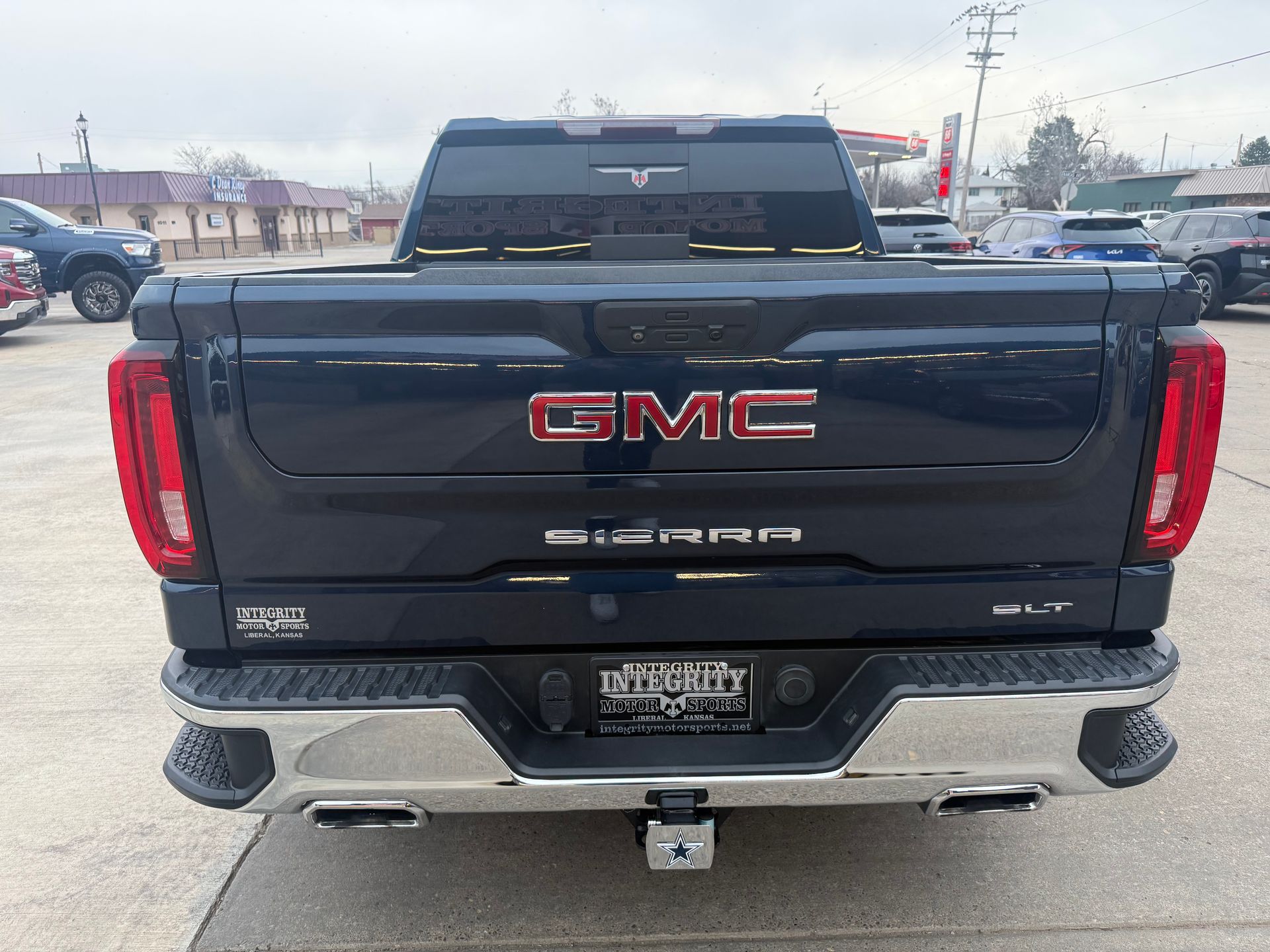 Dark blue GMC Sierra truck, rear view, chrome bumper,