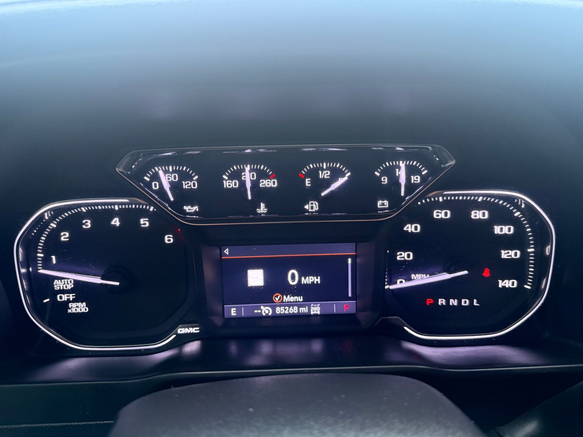 Dashboard of a vehicle showing gauges and a central display. Speedometer reads 0 mph.