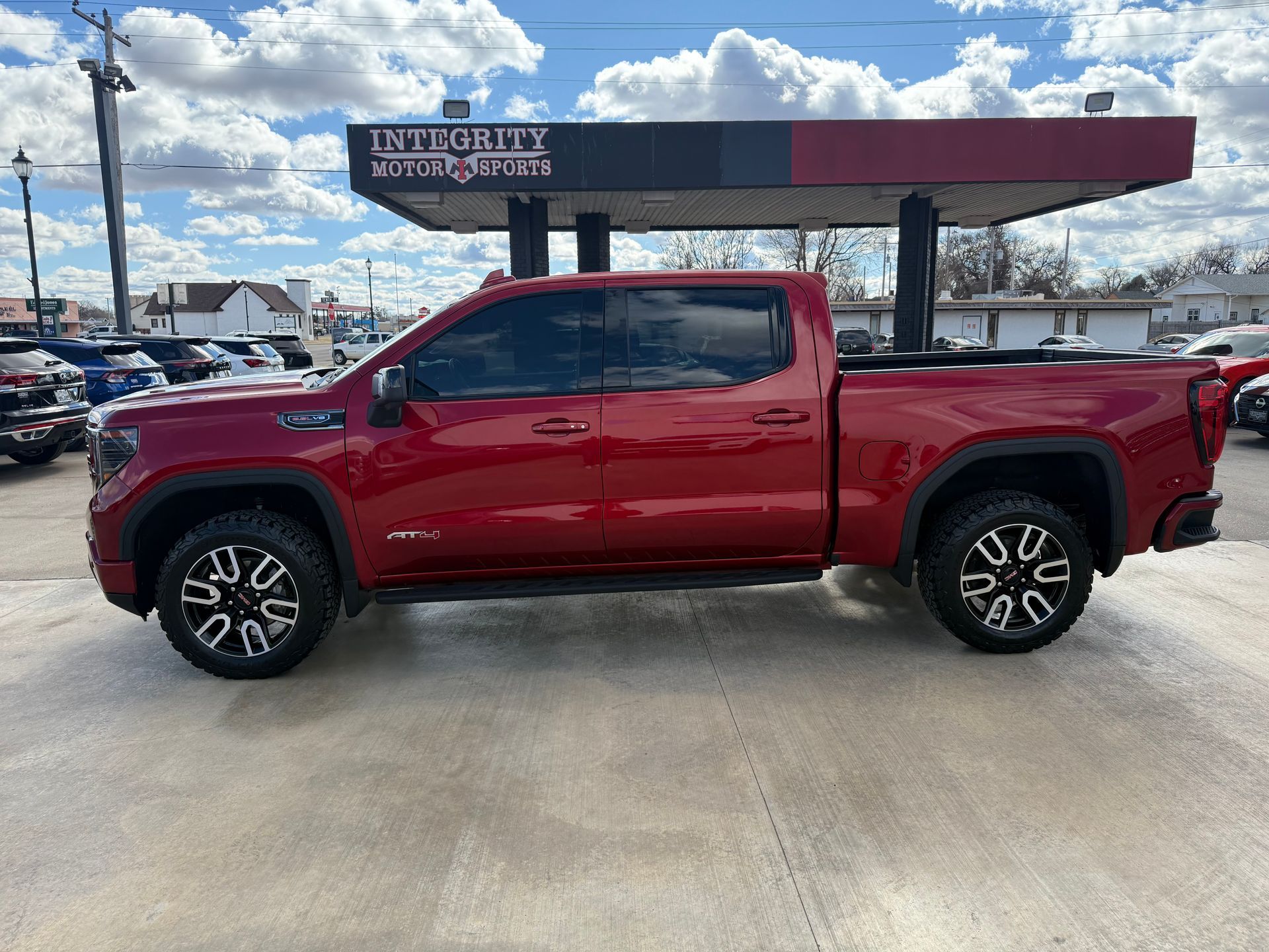 Red GMC truck parked outside Integrity Motors dealership.