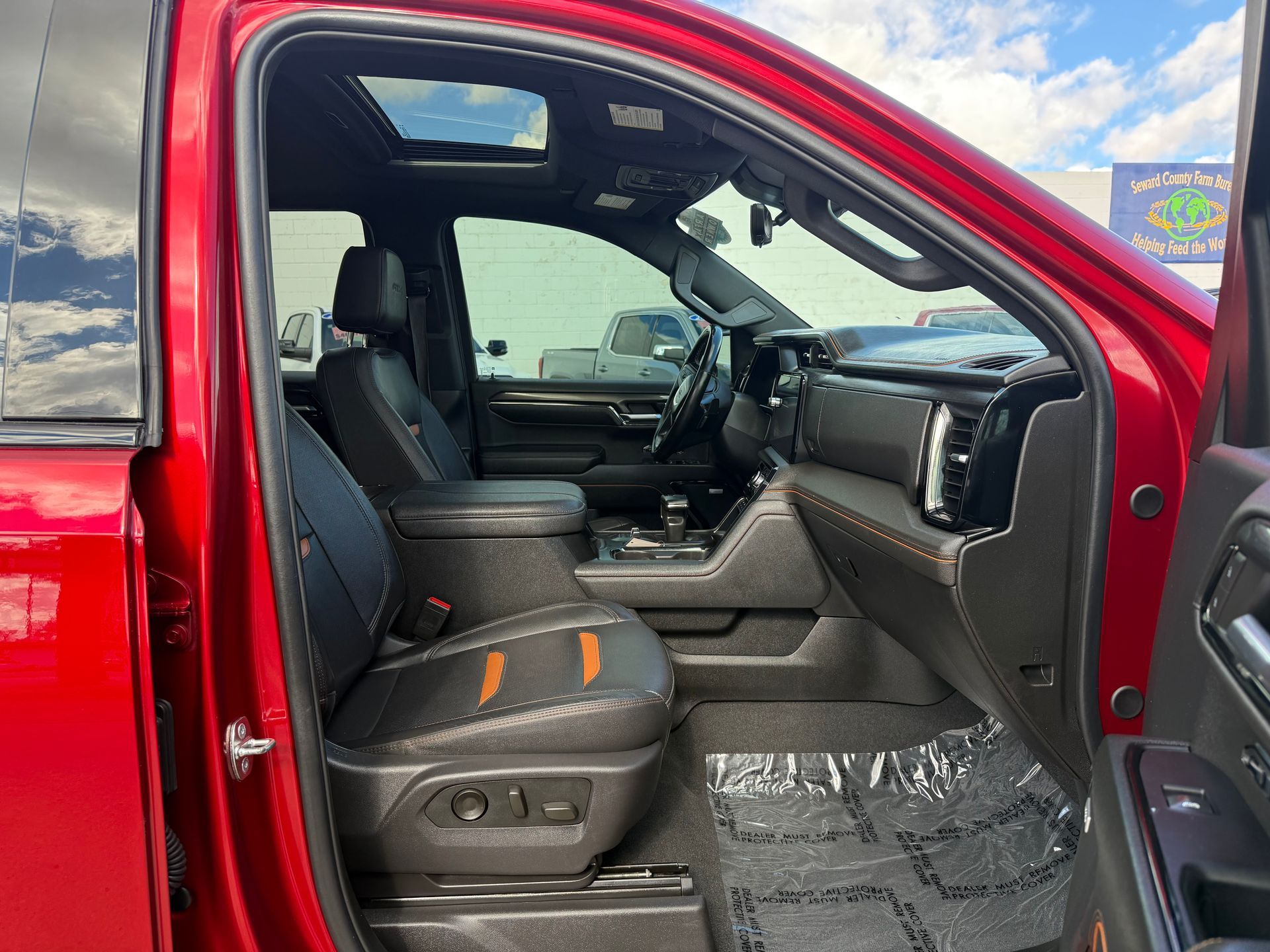 Red truck interior with black leather seats, orange stitching, and sunroof.