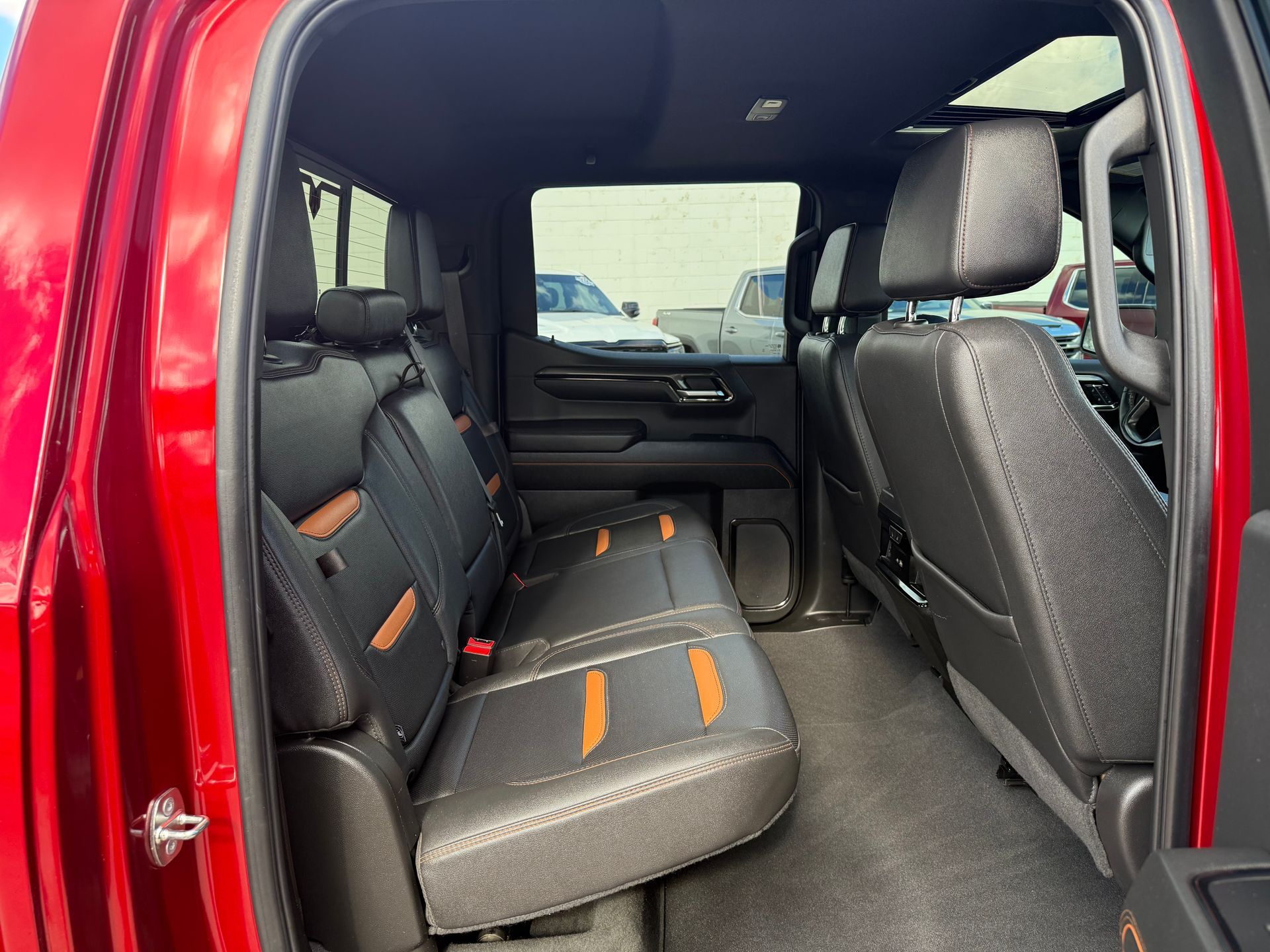 Red truck interior with black leather seats, orange accents.