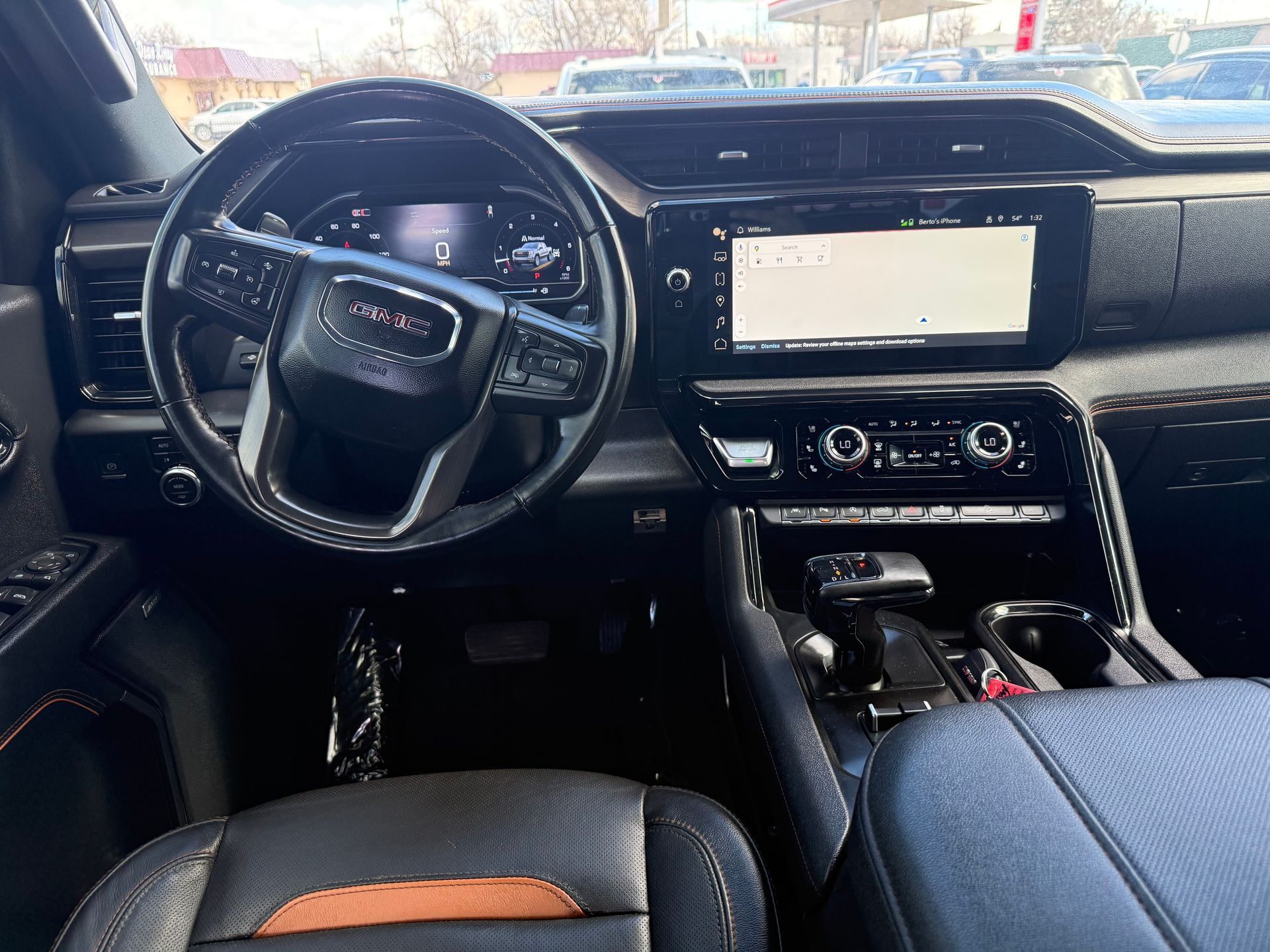 GMC truck interior: black dashboard, steering wheel, infotainment screen, and seats.