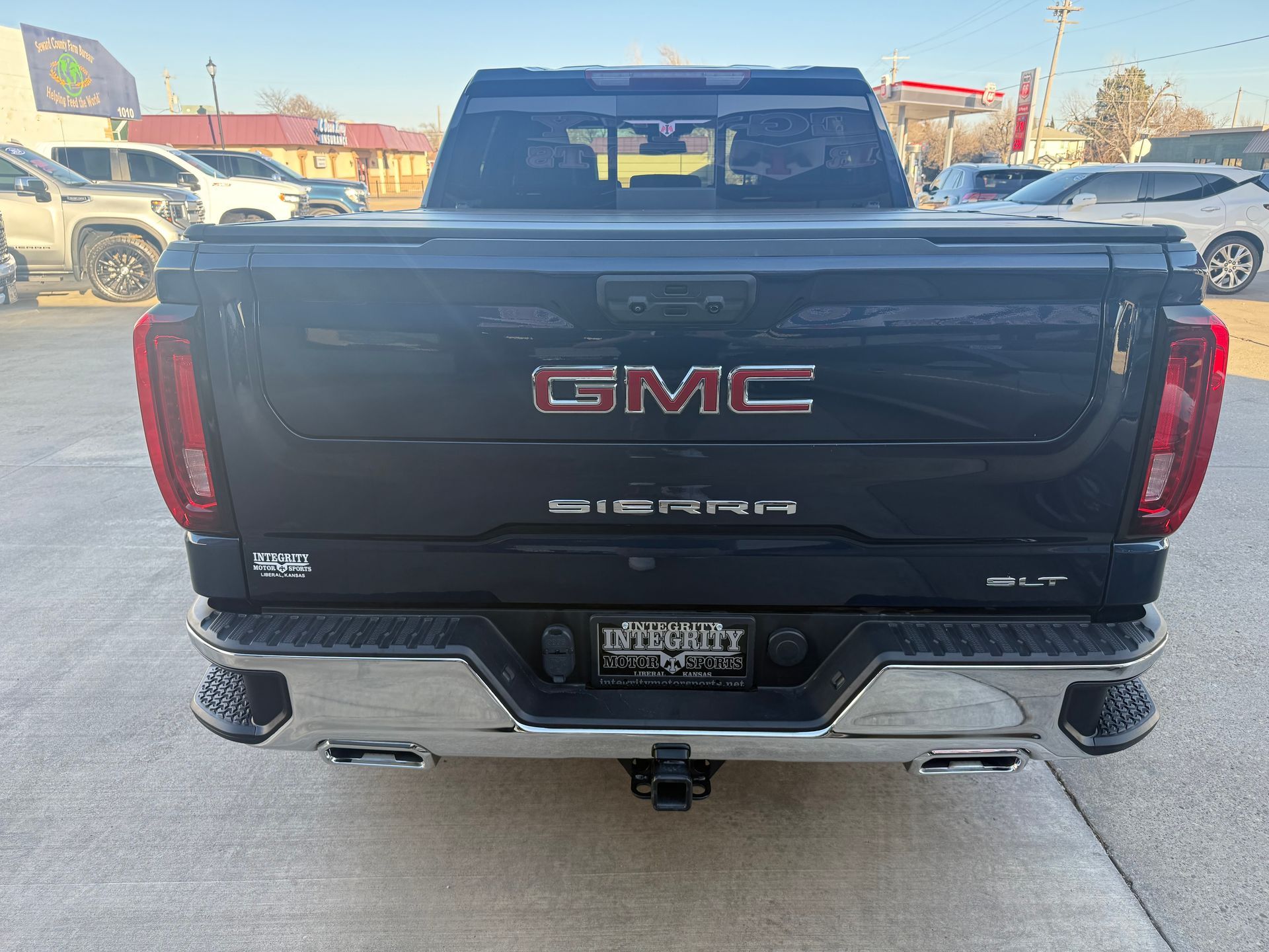 Rear view of a black GMC Sierra truck with a chrome bumper;