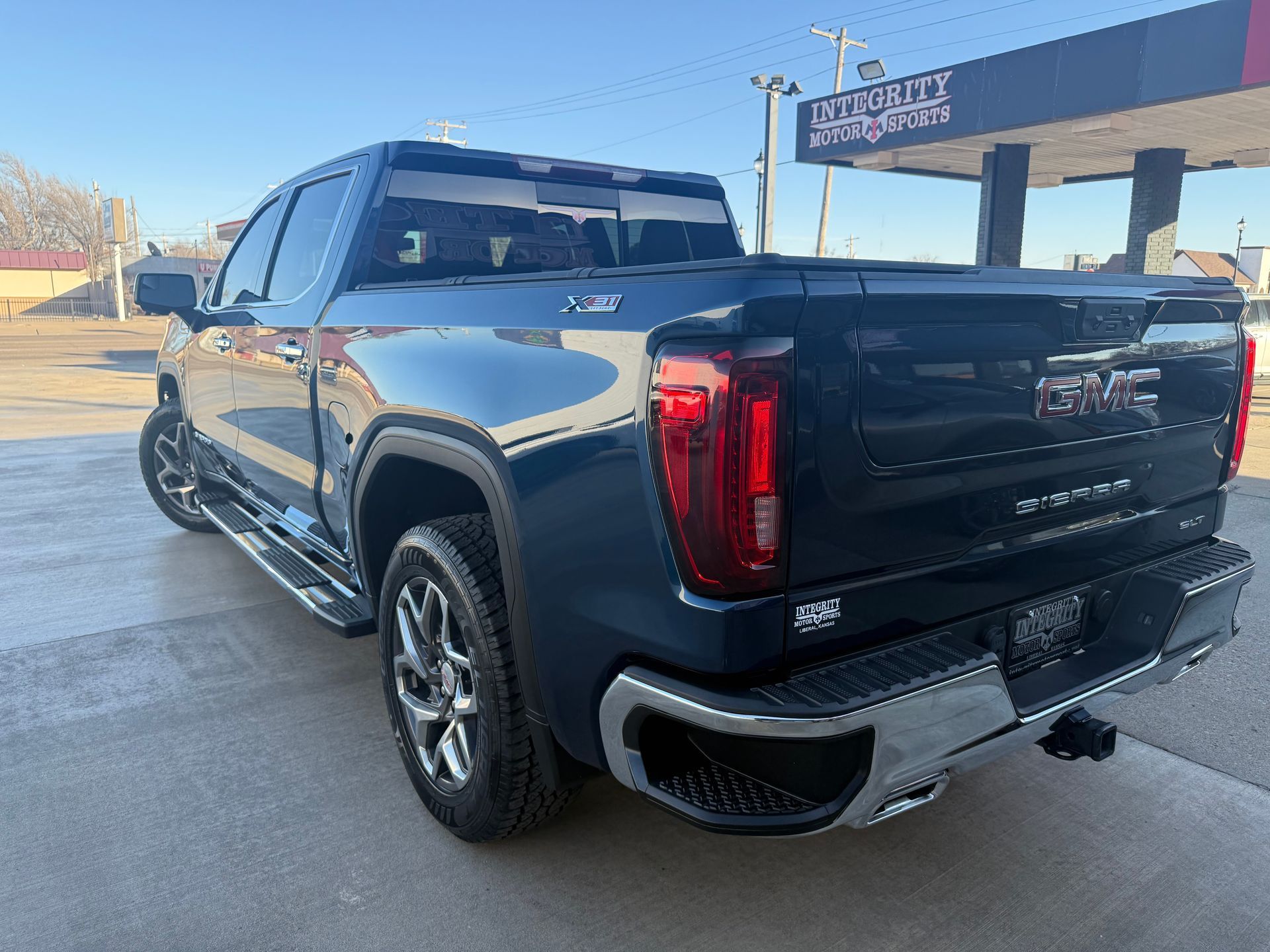 Blue GMC Sierra truck parked on pavement.
