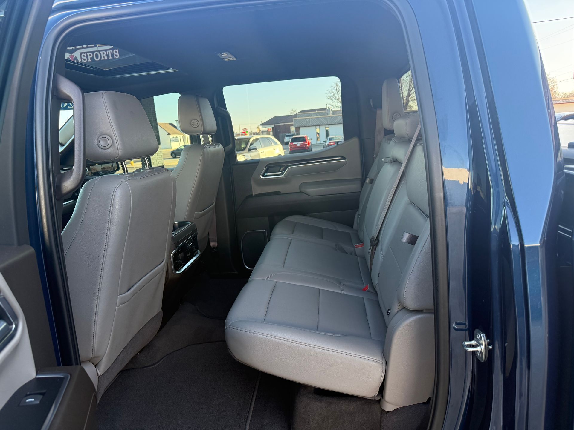 Interior of a blue pickup truck with gray leather seats and a sunroof.