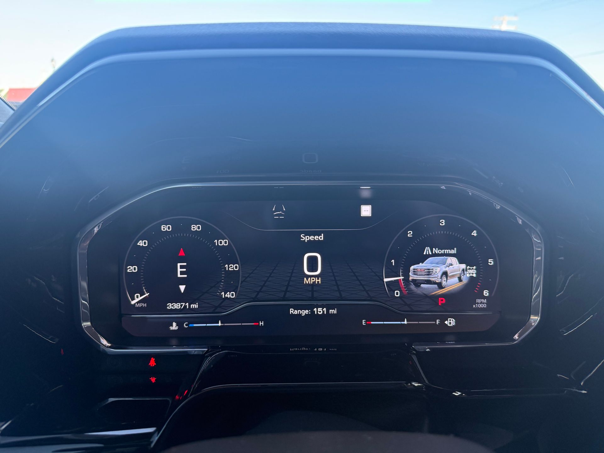 Dashboard with digital display showing speedometer, fuel gauge, and vehicle graphics.