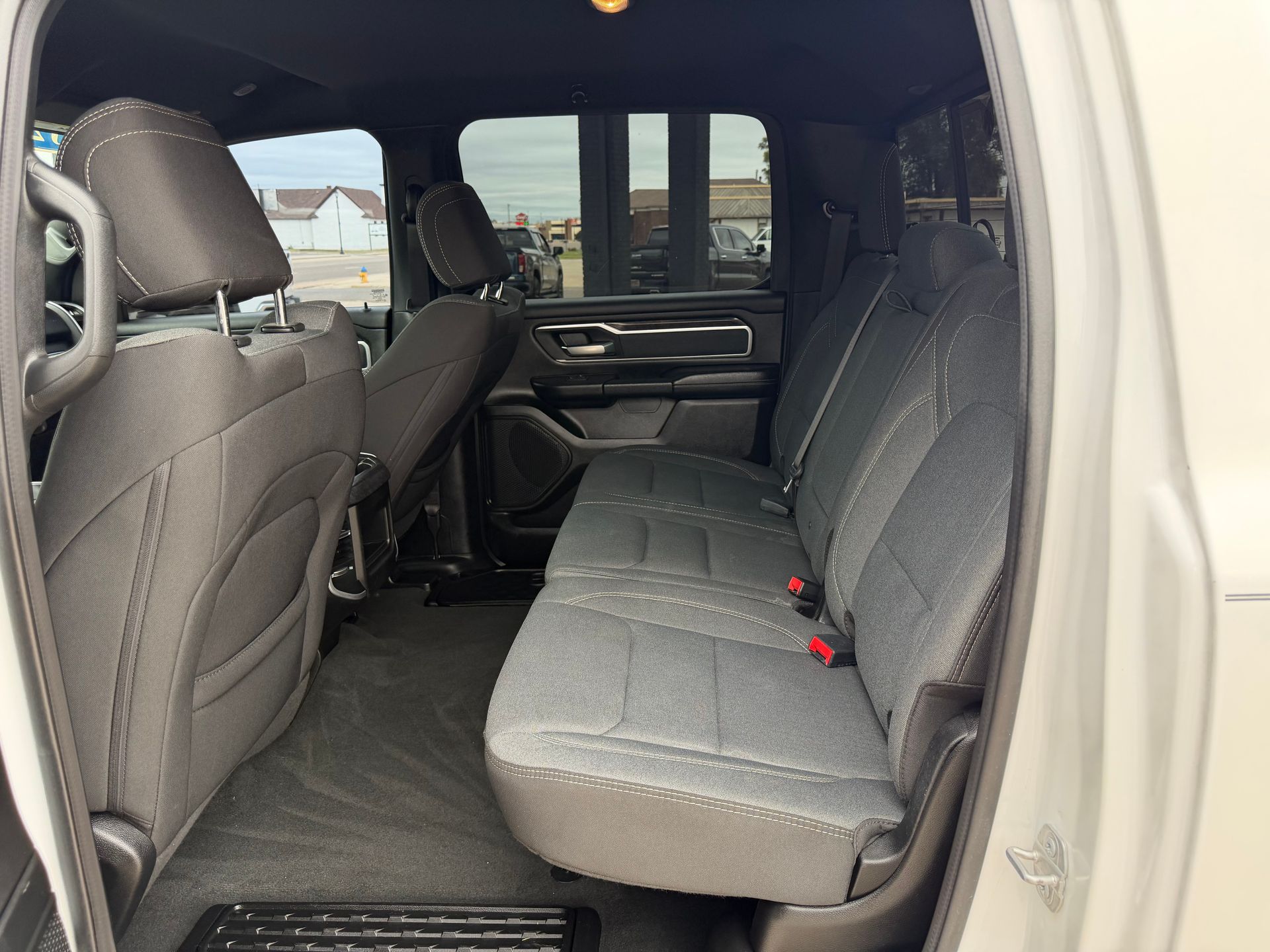 Interior of a van with gray seats and black floor, viewed through the open side door.