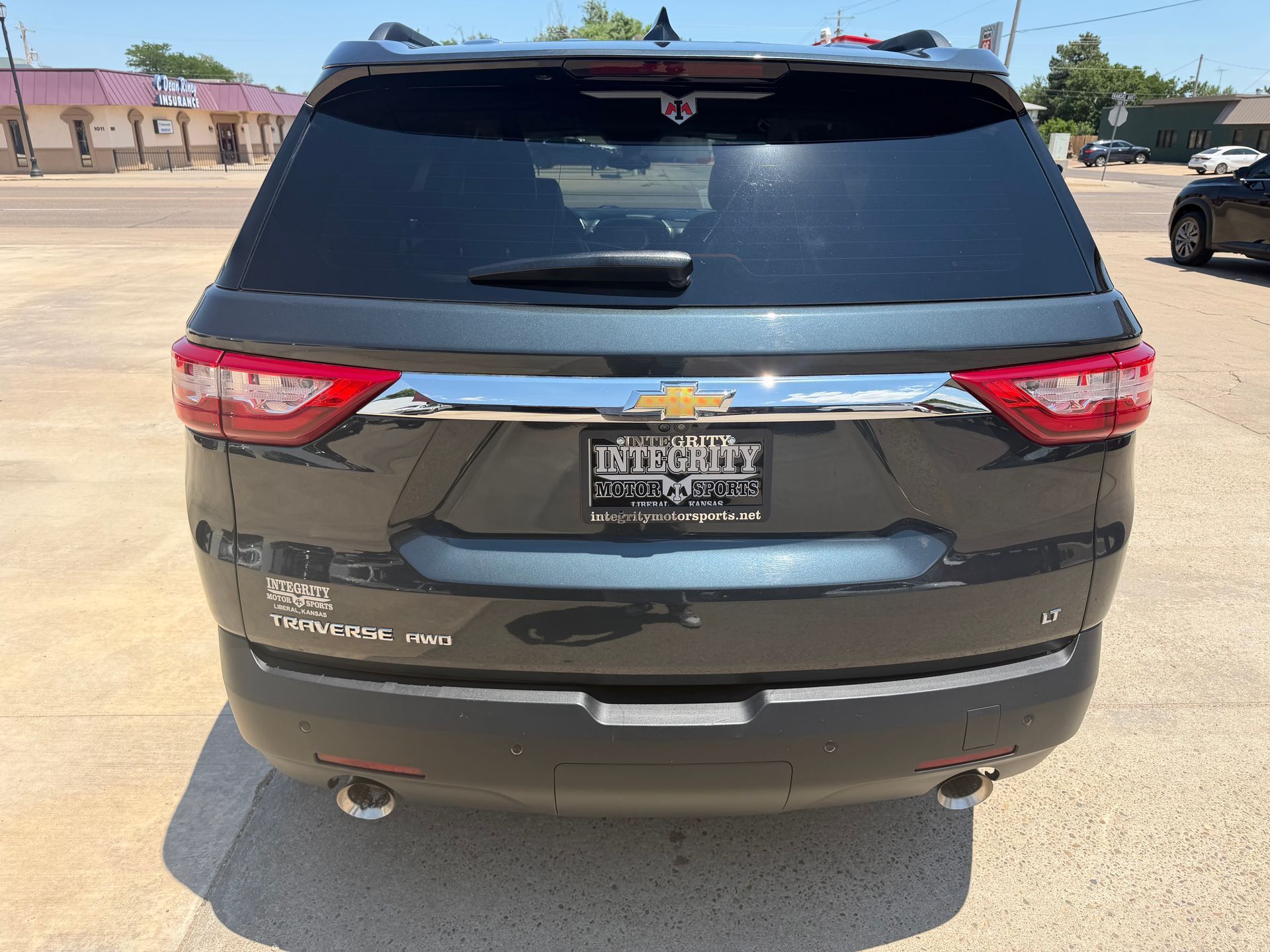 Rear view of a black Chevrolet SUV parked in a sunny lot