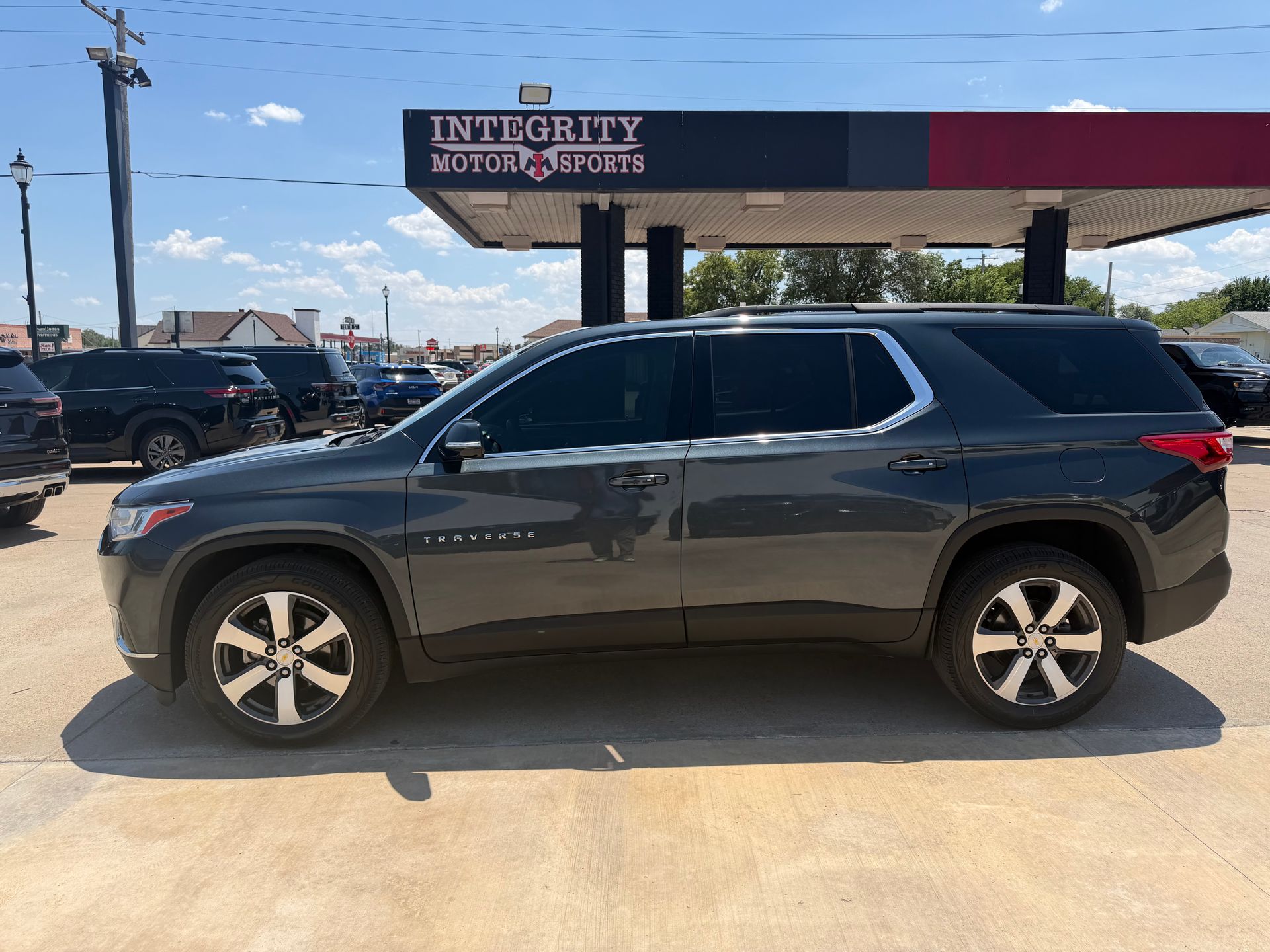 Dark gray SUV parked outside Integrity Motorcars on a sunny day