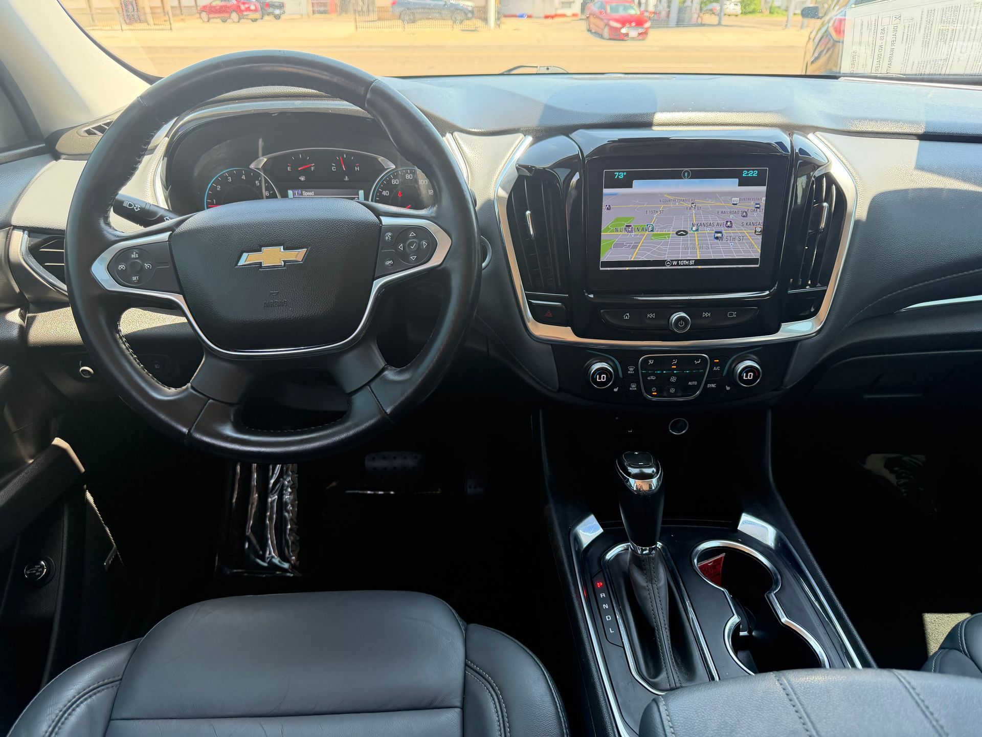 Chevrolet car interior with steering wheel, touchscreen dashboard, and center console seen from the driver’s seat