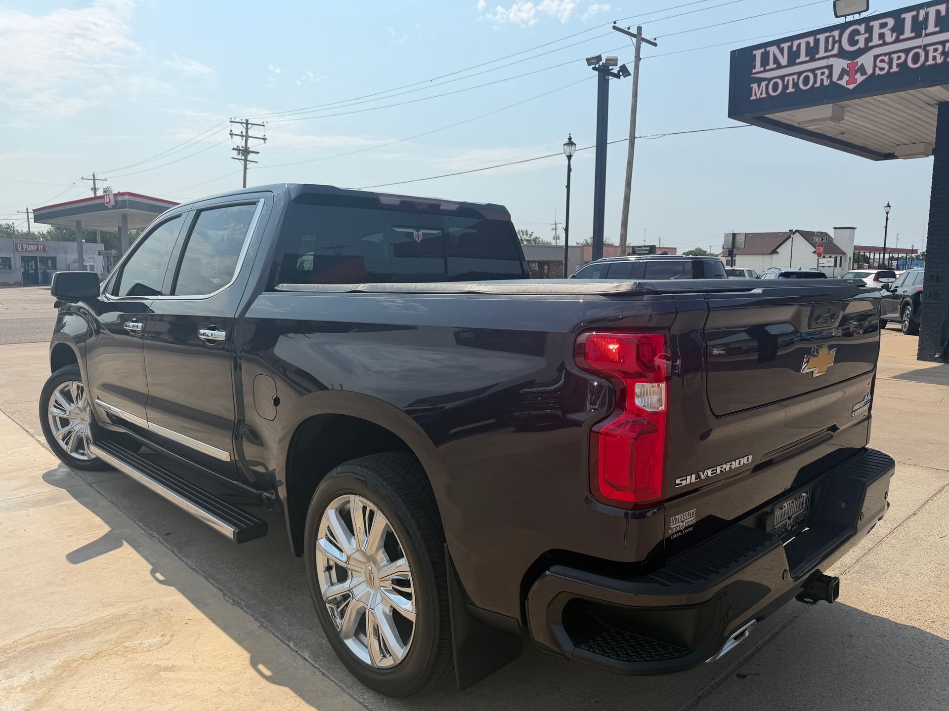Black pickup truck parked outdoors at a dealership lot under a clear sky