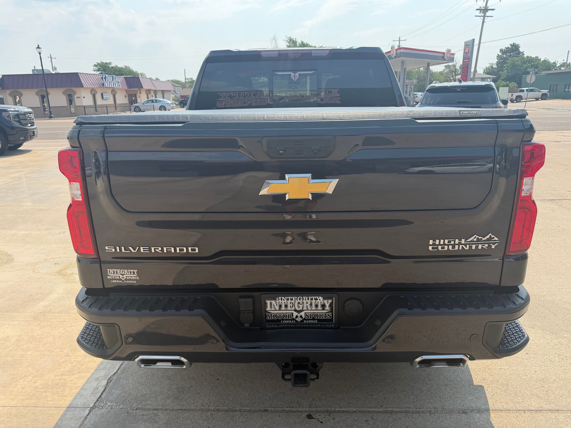 Rear view of a black Chevrolet Silverado pickup truck in a parking lot.
