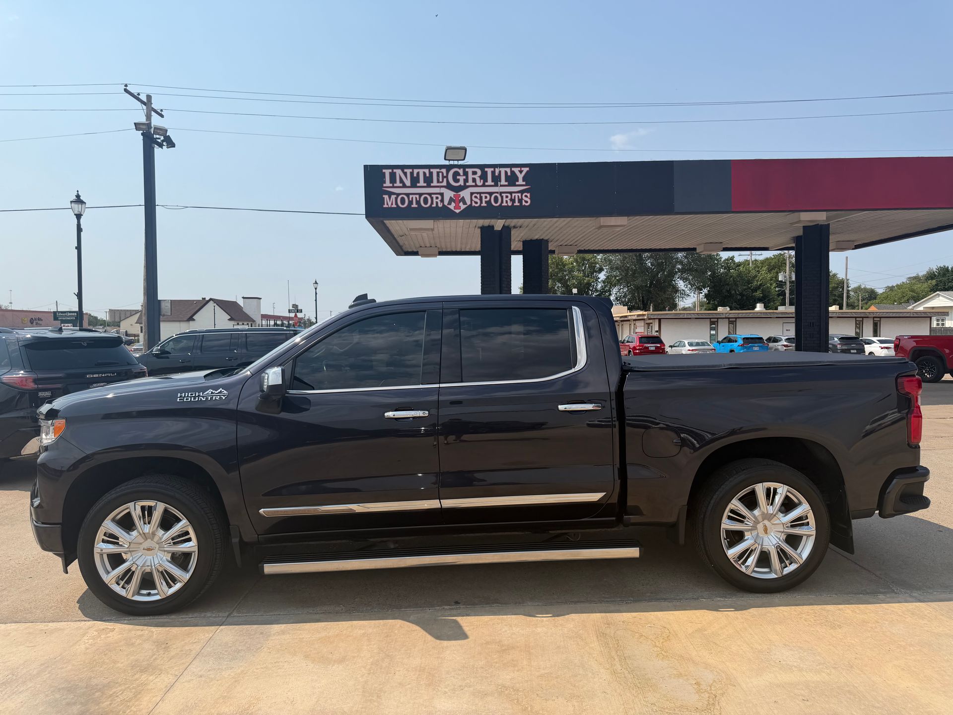 Black pickup truck parked outside a store with an awning and sign