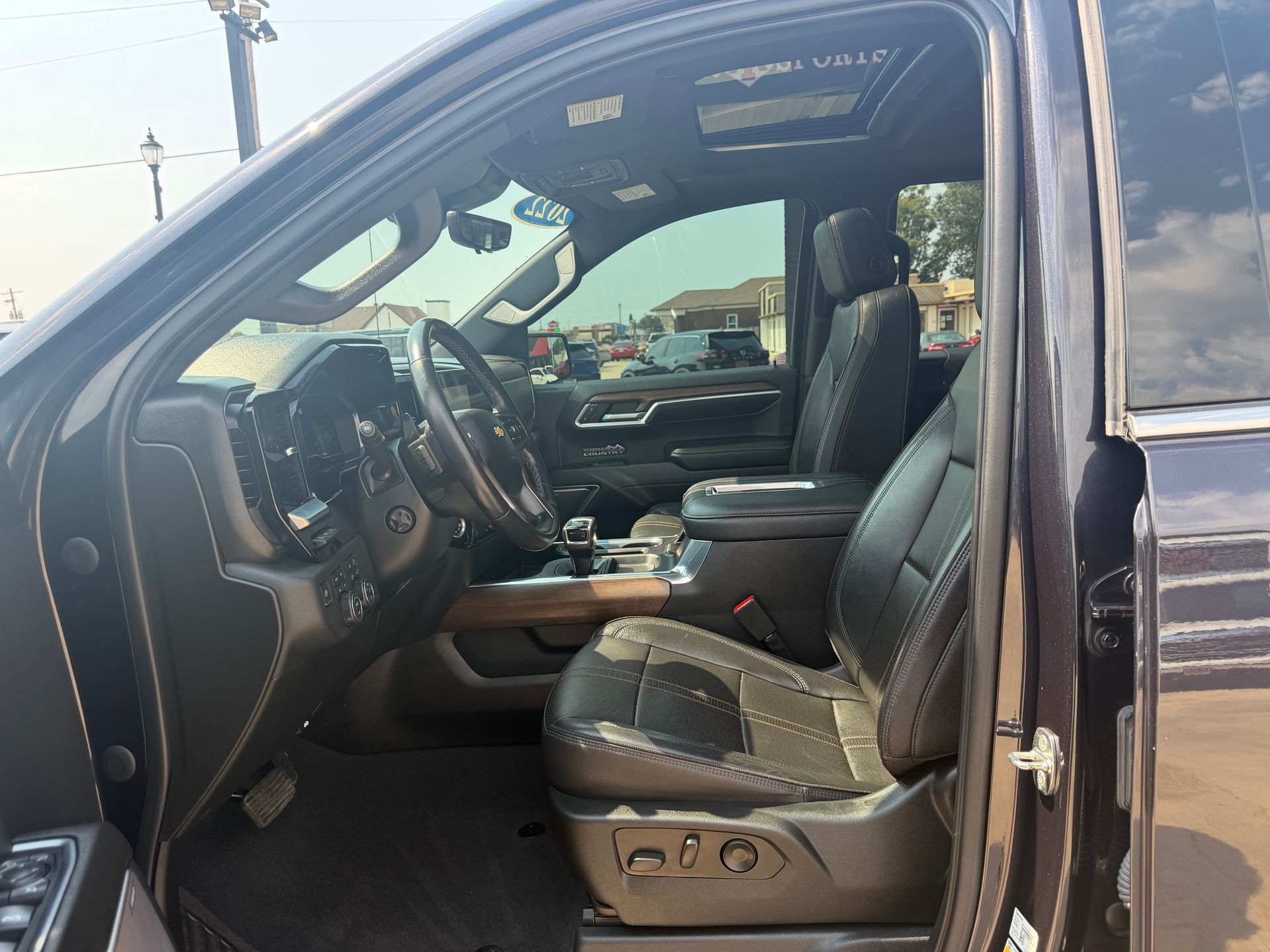 Open SUV driver-side interior with black leather seats and dashboard visible through the open door