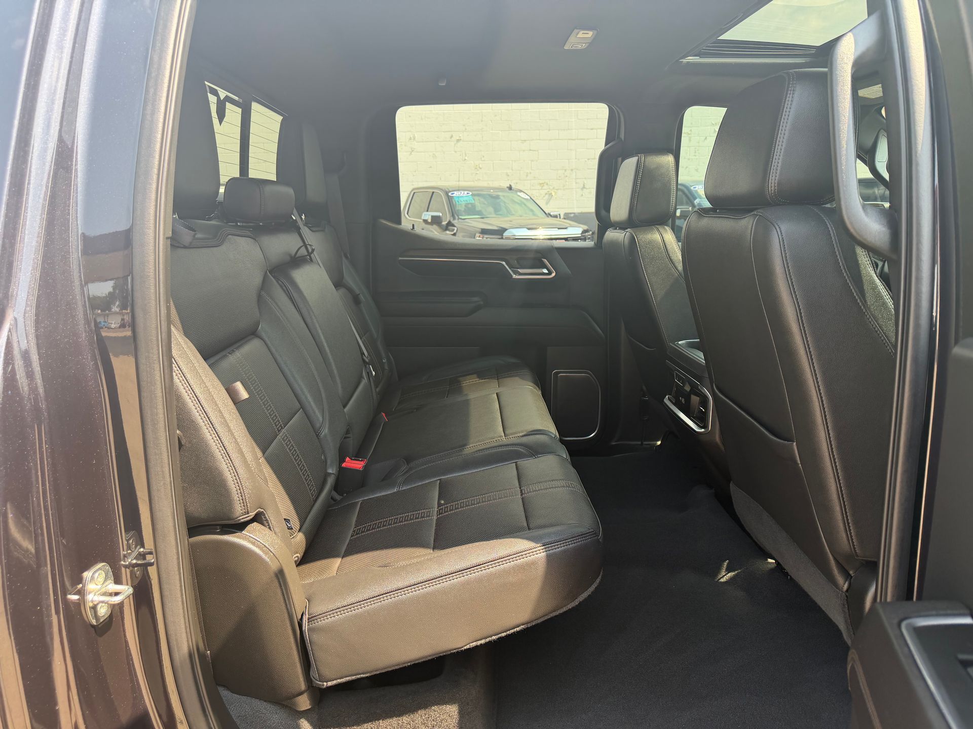 Open car interior with black leather seats and folded second-row seat.