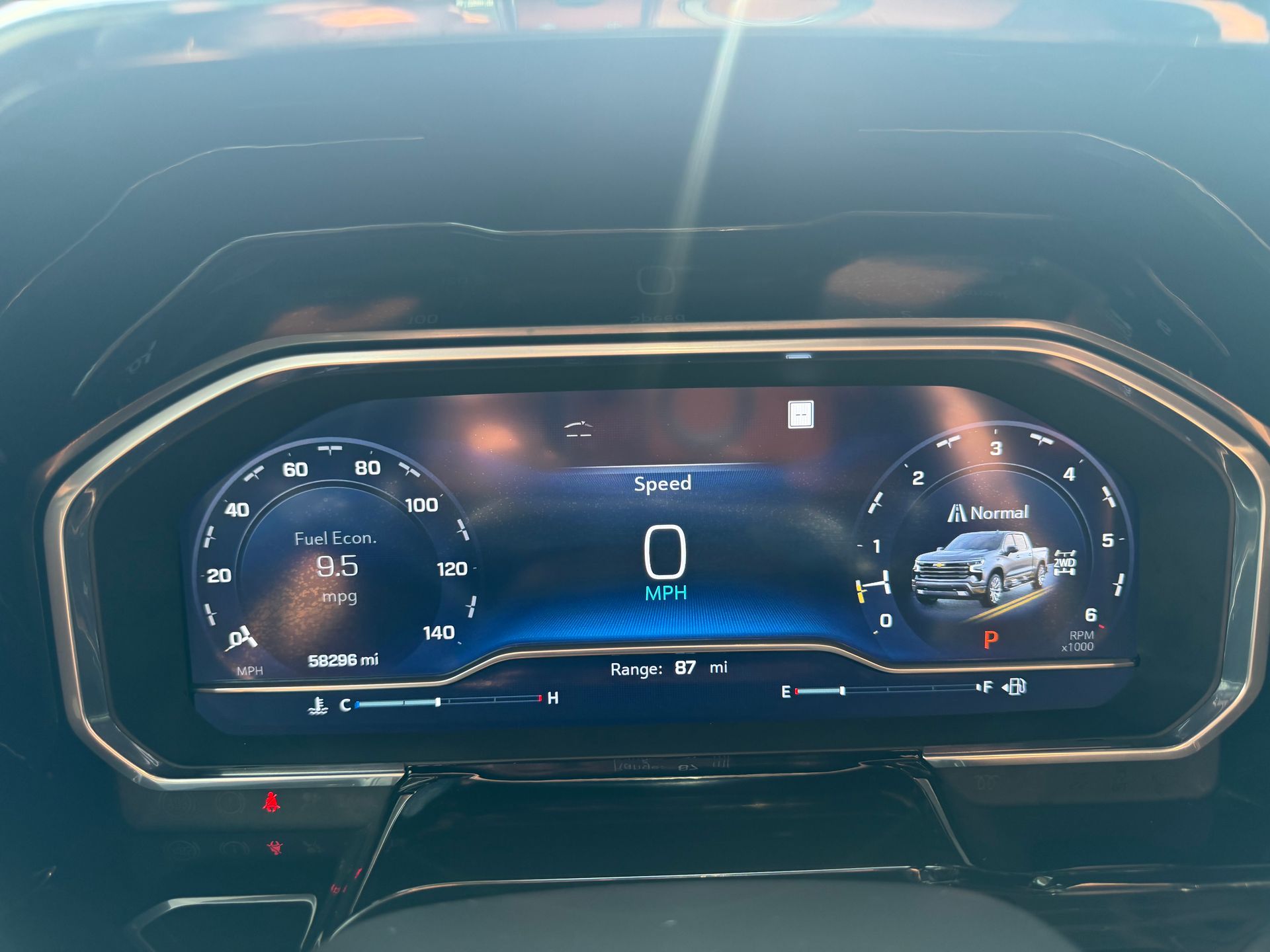 Car dashboard digital instrument cluster showing speed and vehicle info in a dark interior