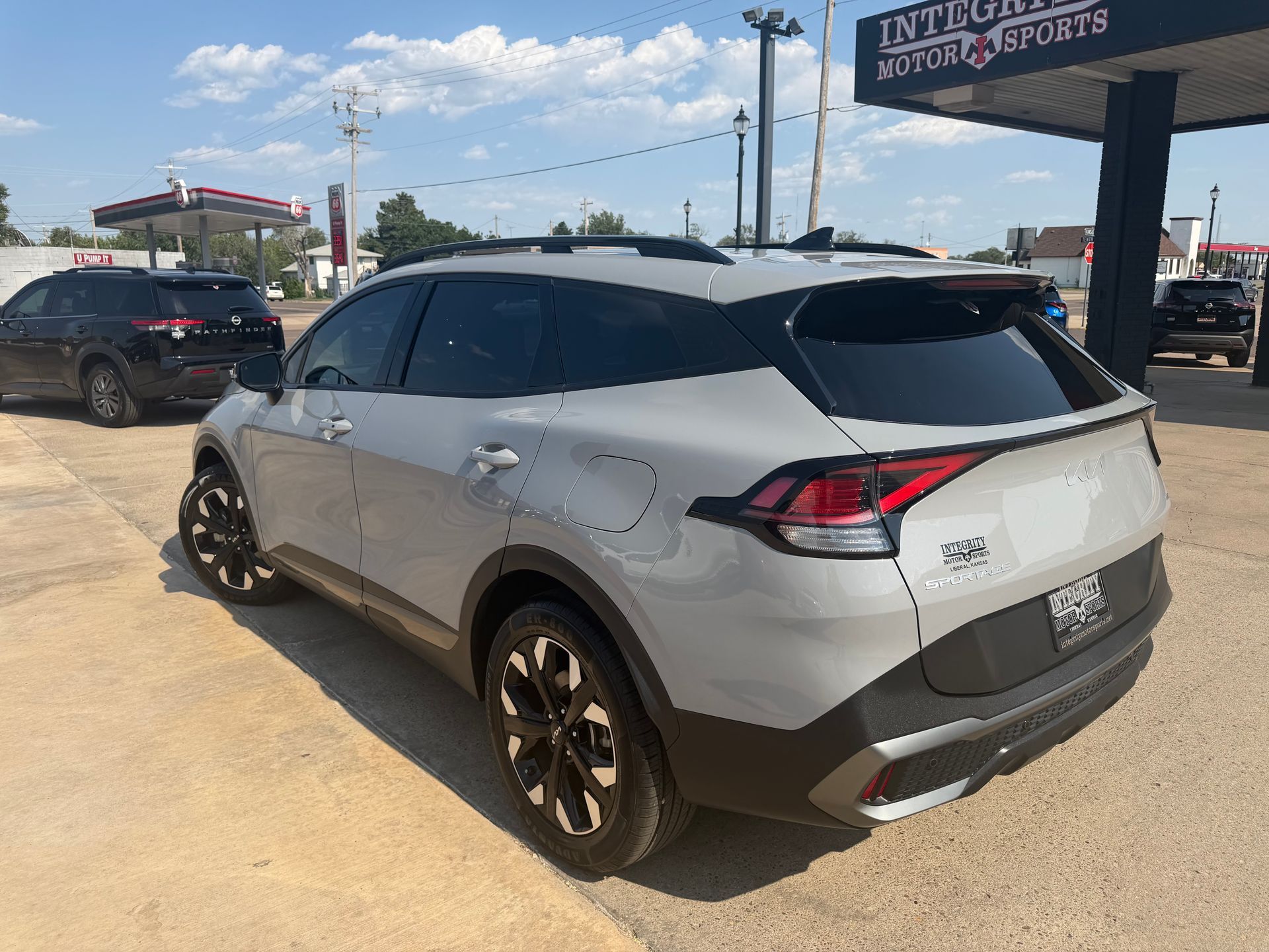 Gray SUV parked outside a dealership under a sunny sky