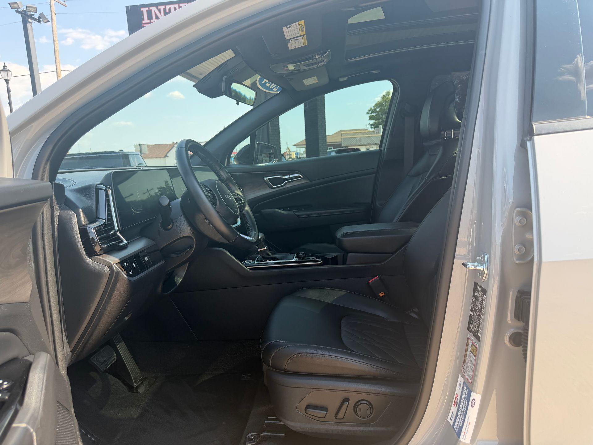 Open car door showing black interior and driver’s seat, with power seat controls visible