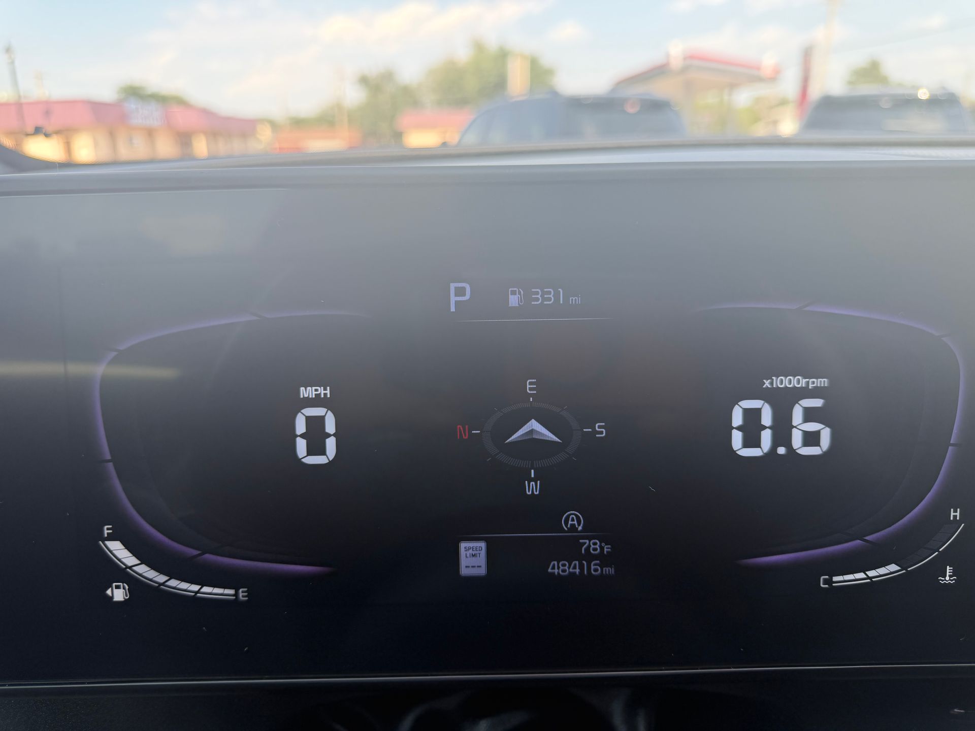 Car dashboard digital display showing speed 0, gear P, and a 0.6 reading at 44°C outside.