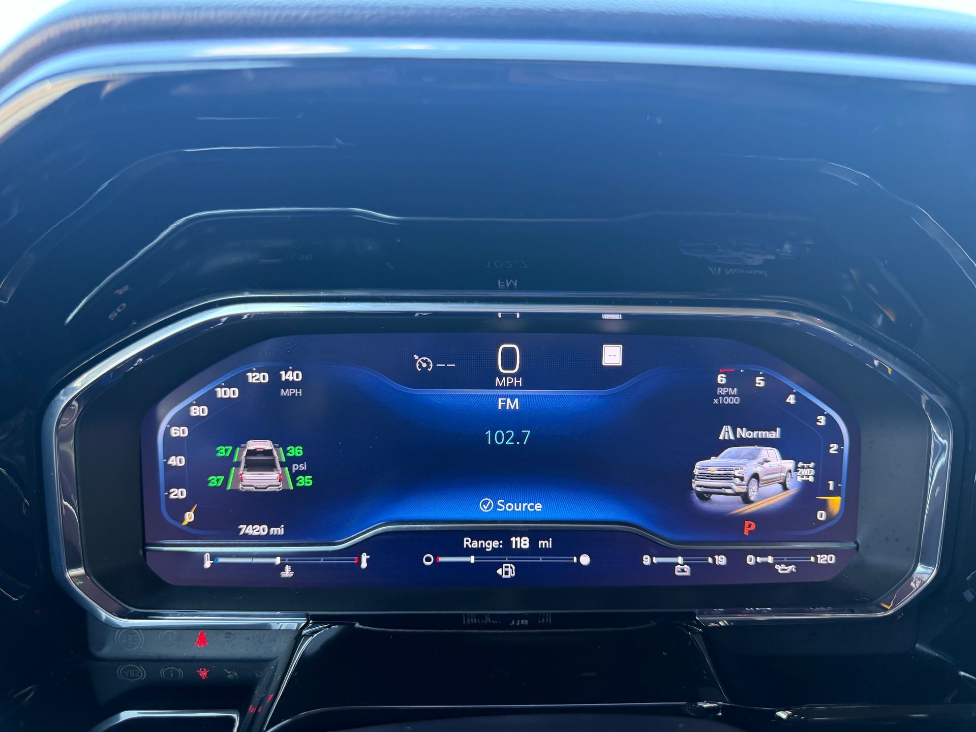 Car dashboard digital instrument cluster displaying 0 mph with navigation and vehicle status icons.